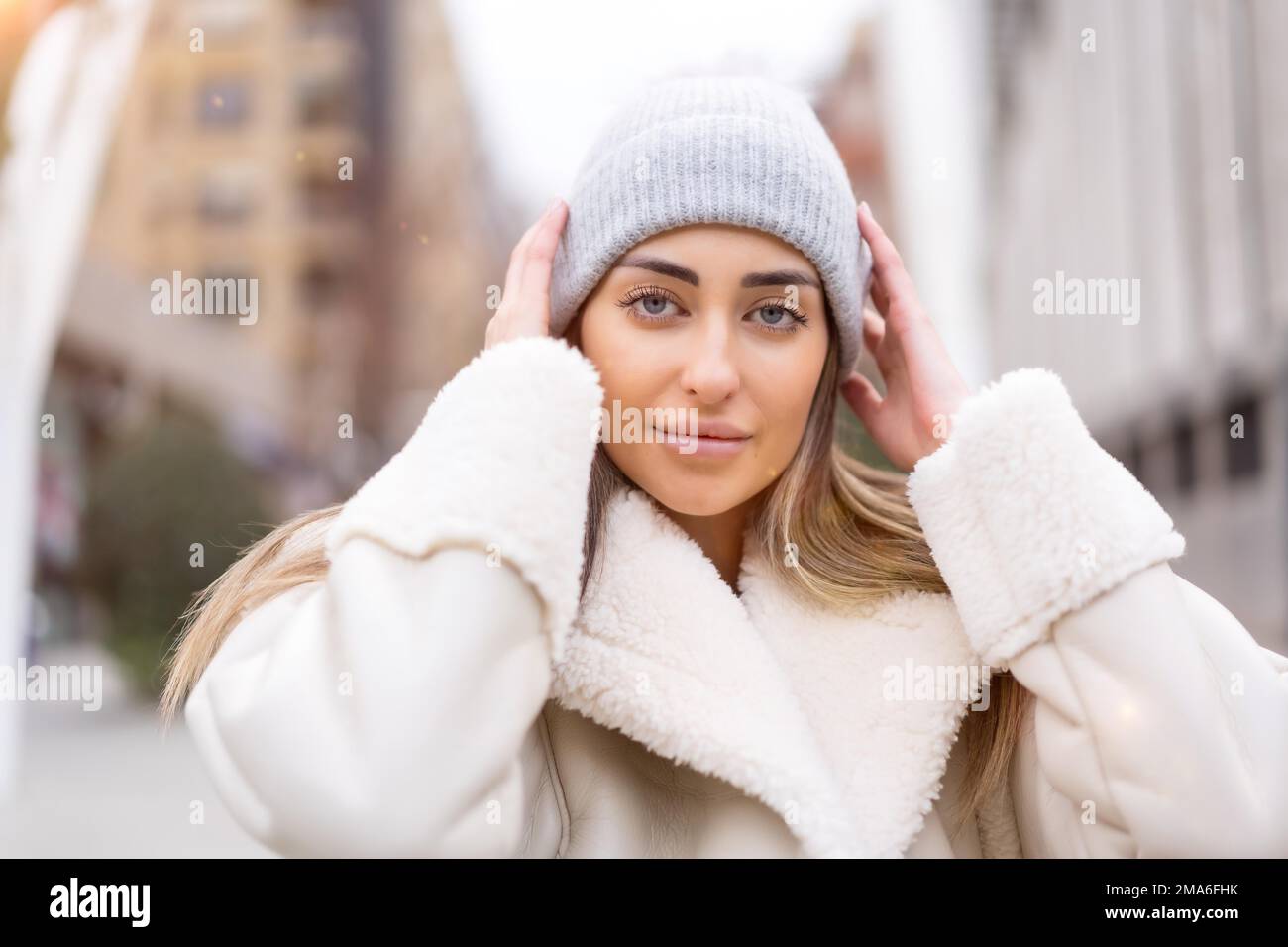 Ritratto invernale di una donna caucasica in un cappello di lana in città, stile di vita Foto Stock