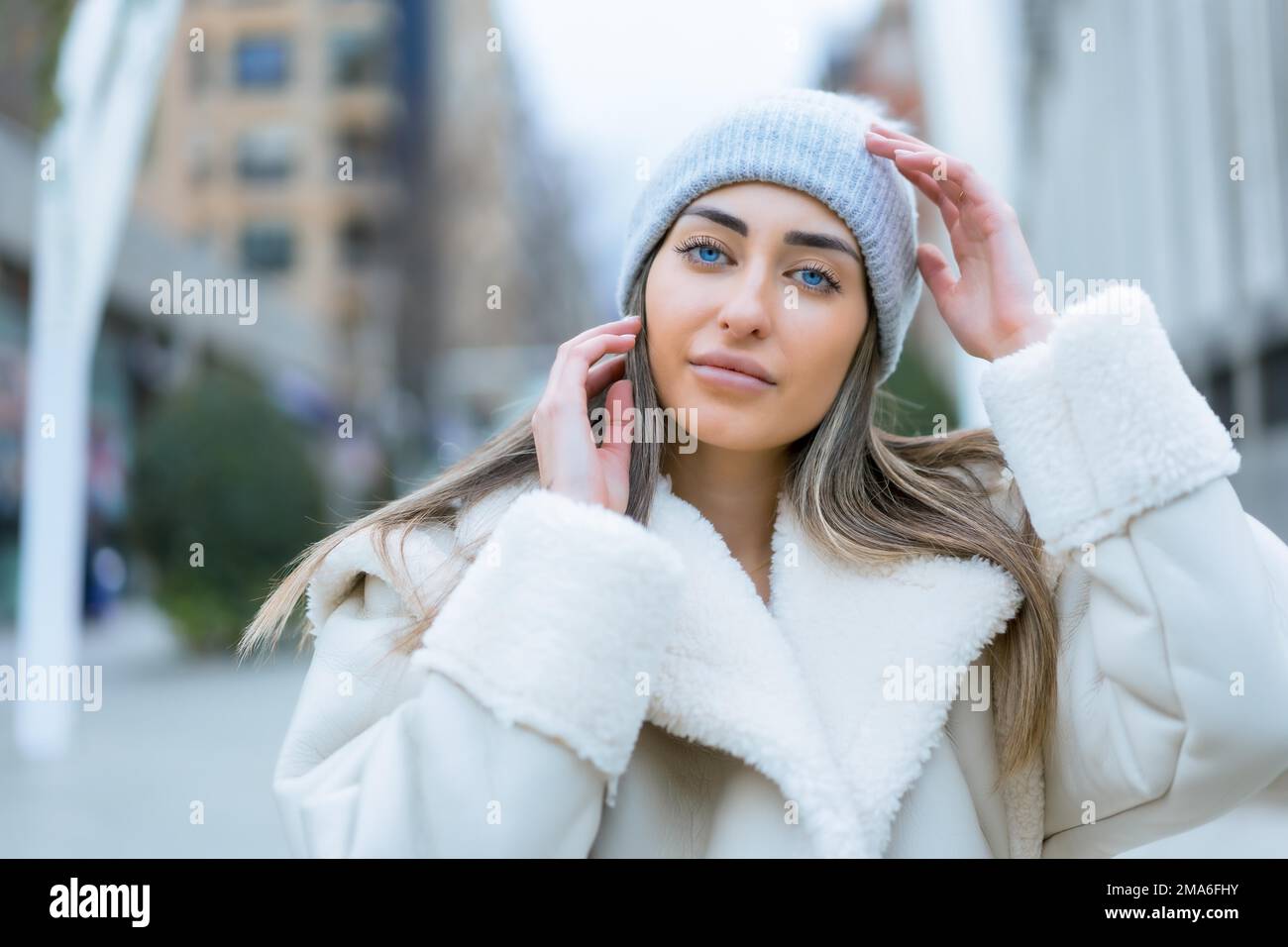 Ritratto invernale di una donna caucasica in un cappello di lana in città, stile di vita Foto Stock