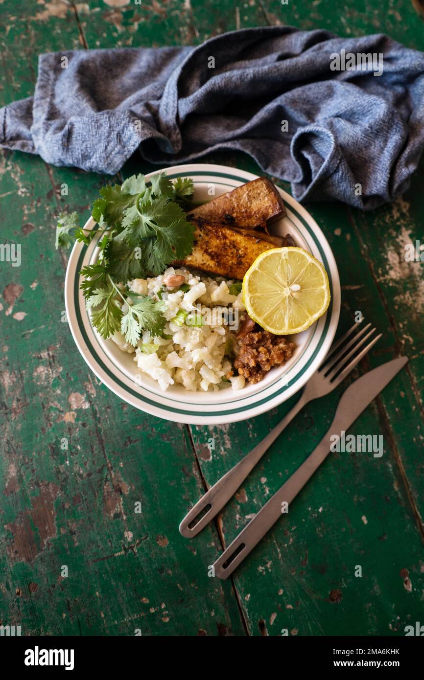 Fotografia alimentare, cavolfiore, insalata, tofu, vegan, vegetariano, alimentazione, salute, limone, prezzemolo Foto Stock