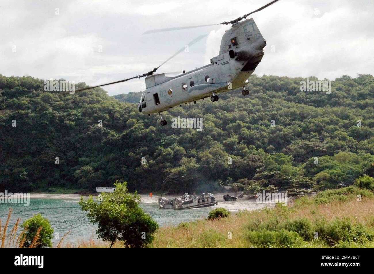 051029-N-9222M-094. [Completa] Caption scena: Un corpo marino degli Stati Uniti (USMC) CH-46E Cavaliere di mare, Marine Medium Helicopter Squadron 262 (rinforzato) (HMM-262), Aviation Combat Element (ACE), 31st Marine Expeditionary Unit (MEU), Marine Corps Air Station (MCAS) New River, North Carolina (NC), E un cuscino d'aria dell'imbarcazione da sbarco della Marina statunitense (USN), l'unità d'artigianato d'assalto 5 (ACU-5) distaccamento del Pacifico occidentale, la base dei corpi marini (MCB) Camp Pendleton, California (CA), conducono un atterraggio simultaneo di truppe e veicoli corazzati durante un esercizio di atterraggio anfibio (PHIBLEX) a Ternate Beach. La bilatera annuale Foto Stock