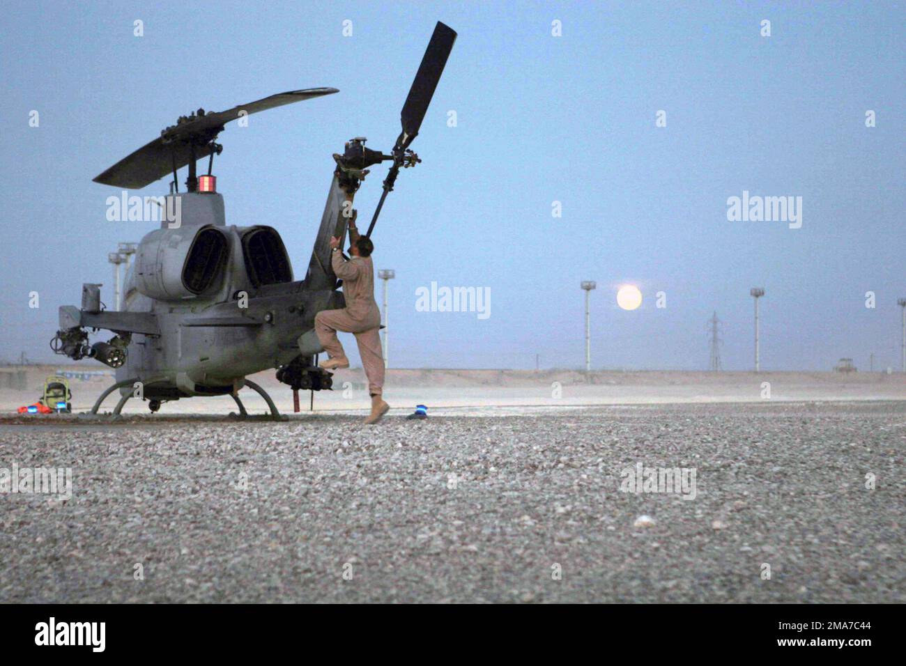 Un US Marine Corps (USMC) AH-1W Super Cobra Helicopter, Marine Light Attack Helicopter Squadron 369 (HML/A-369), Marine Corps base (MCB) Camp Pendleton, California (CA), è preparato per un decollo notturno dalla Forward Operation base (FOB) al Qaim, Fornire uno stretto sostegno aereo alle forze di coalizione durante l'operazione cortina d'acciaio nell'ambito dell'operazione LIBERTÀ IRACHENA. Base: Fob al Qaim Stato: Al Anbar Paese: Iraq (IRQ) Foto Stock