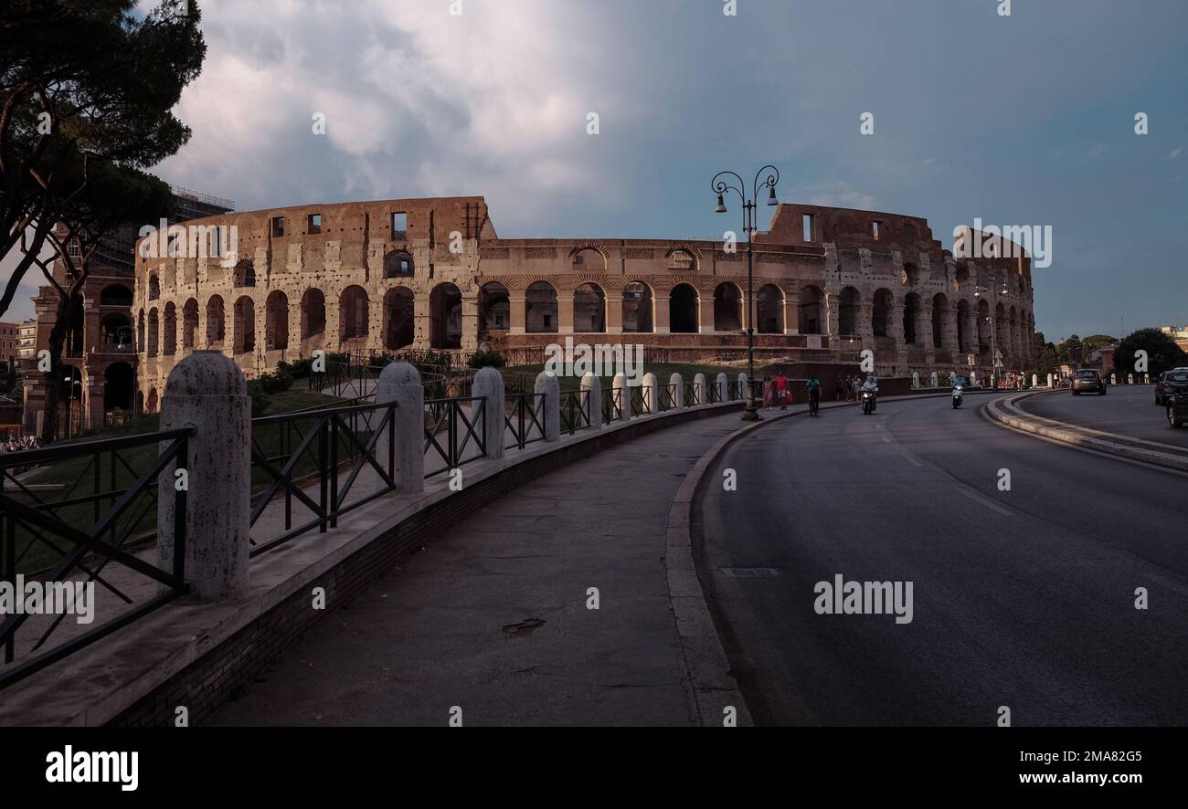 Il Colosseo a Roma visto dalla strada che crea una linea curva di testa verso l'anfiteatro. Foto Stock