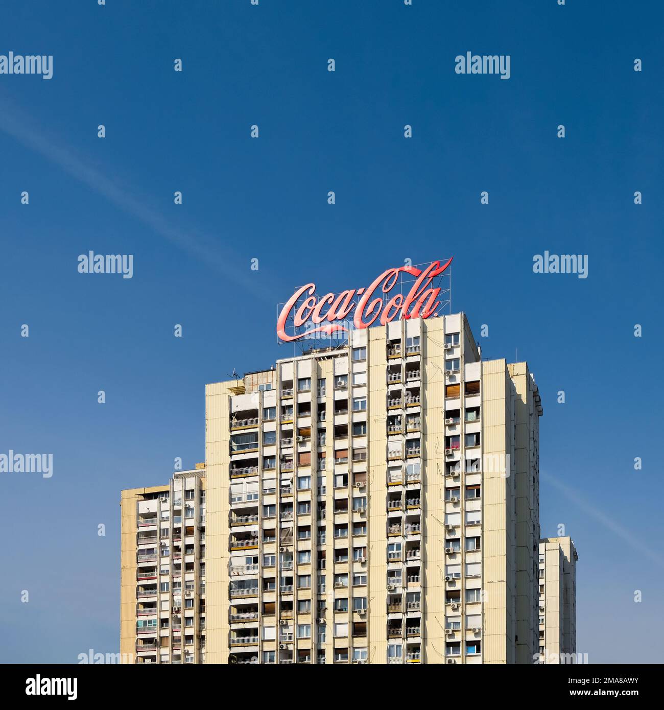 Edificio a torre con grande cartello Coca Cola in cima. Cielo su sfondo blu in una giornata di sole. Foto Stock