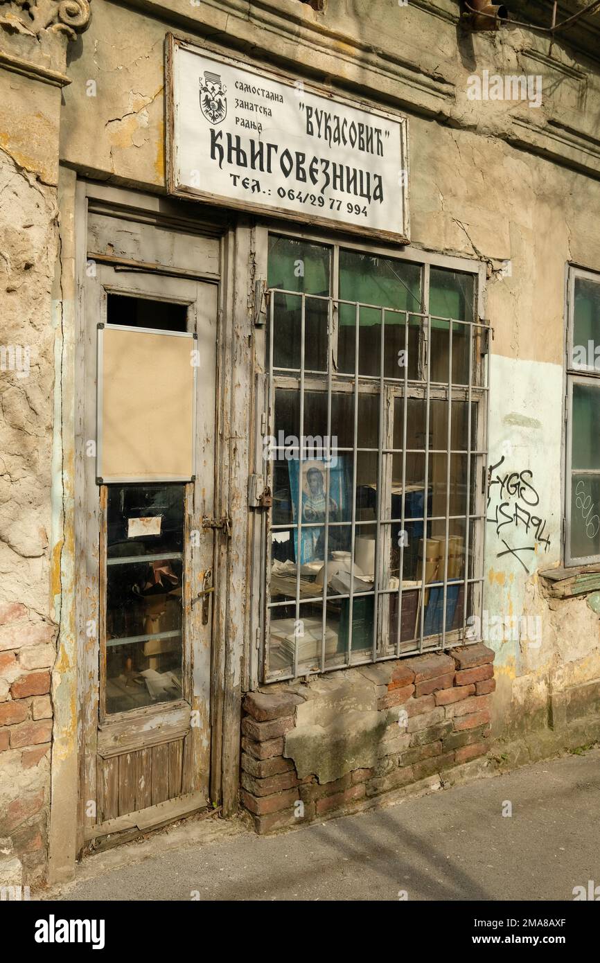 Vecchio negozio di fronte a Belgrado che guarda abbandonato o in disuso con un ritratto di Gesù all'interno della finestra anteriore che è bloccato e con lucchetto. Foto Stock