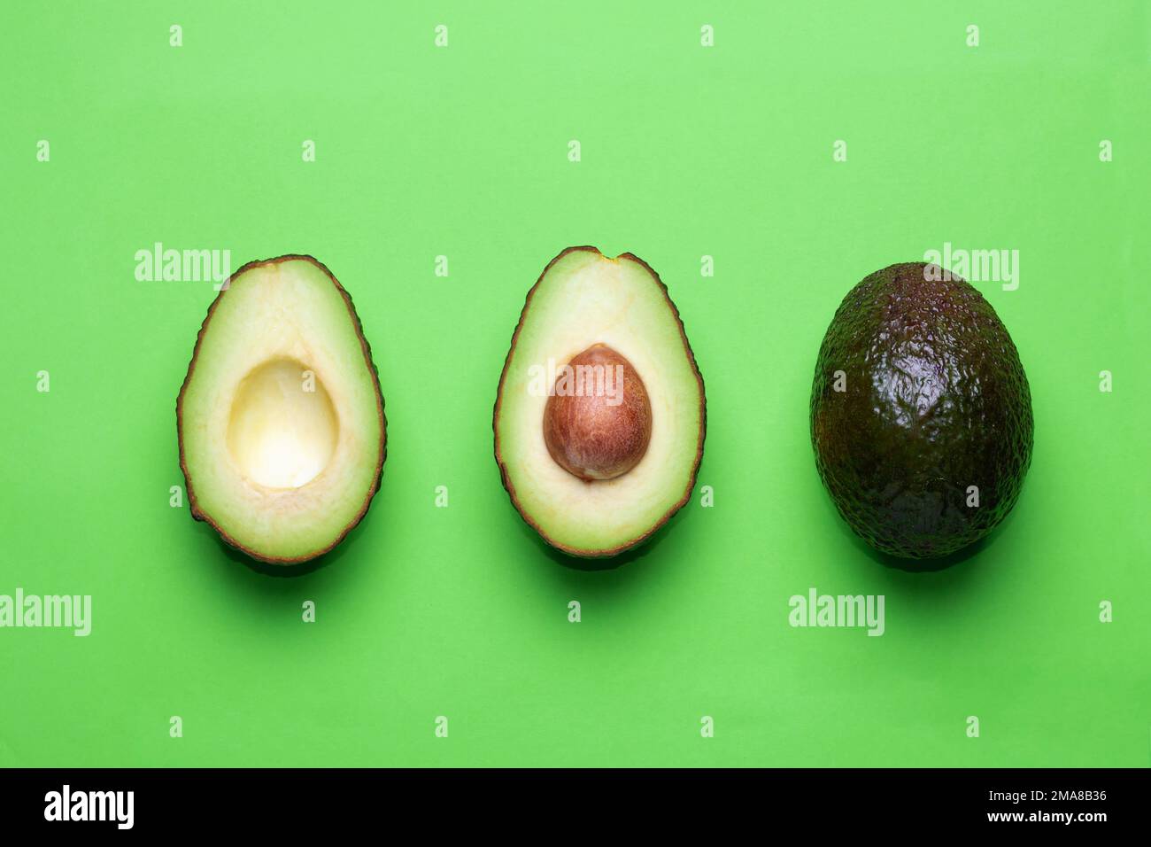 Avocado fresco a fette su sfondo verde. Foto Stock