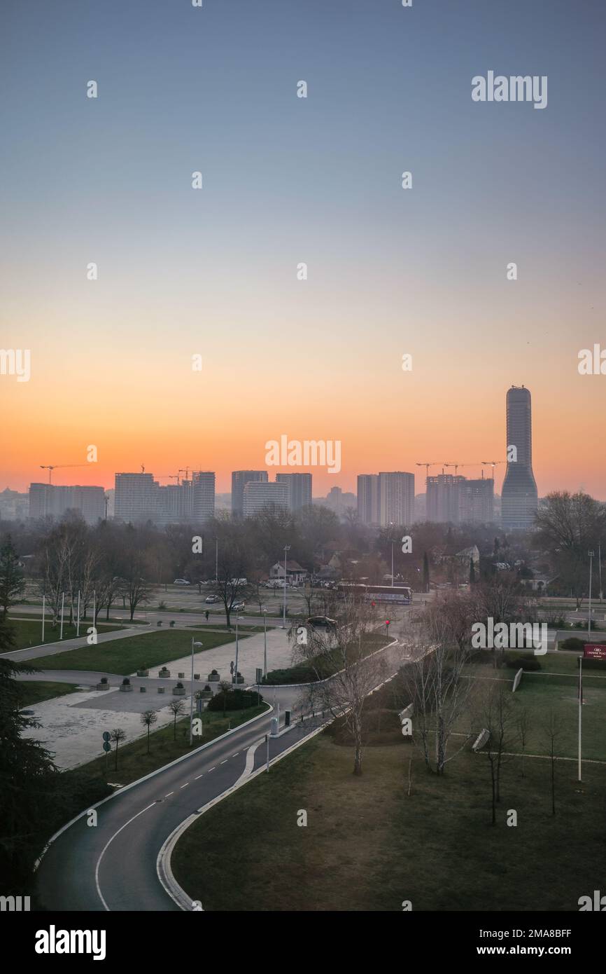 Skyline di Belgrado all'alba con strada che vi conduce. Belgrado torre, edifici e gru da cantiere visibili. Formato verticale con spazio di copia. Foto Stock