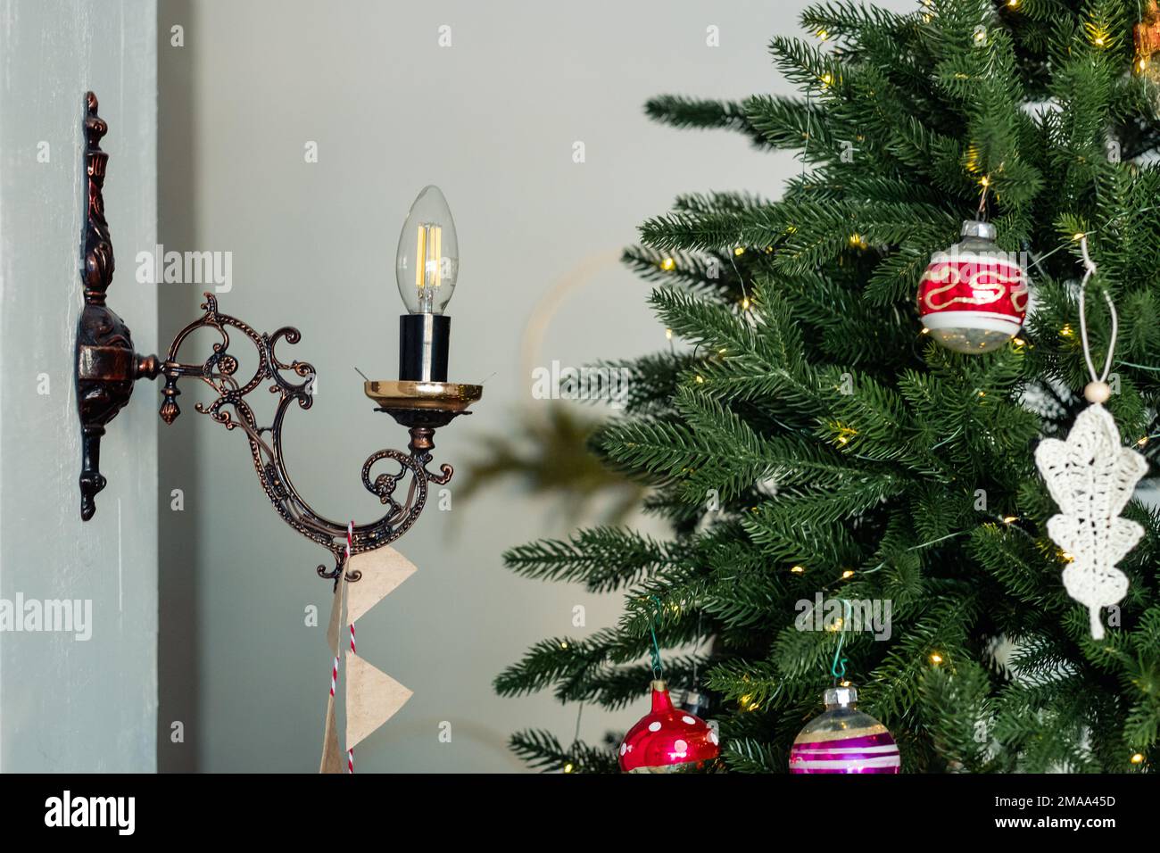 Lampada a candela in un candelabro vicino all'albero di Natale Foto Stock