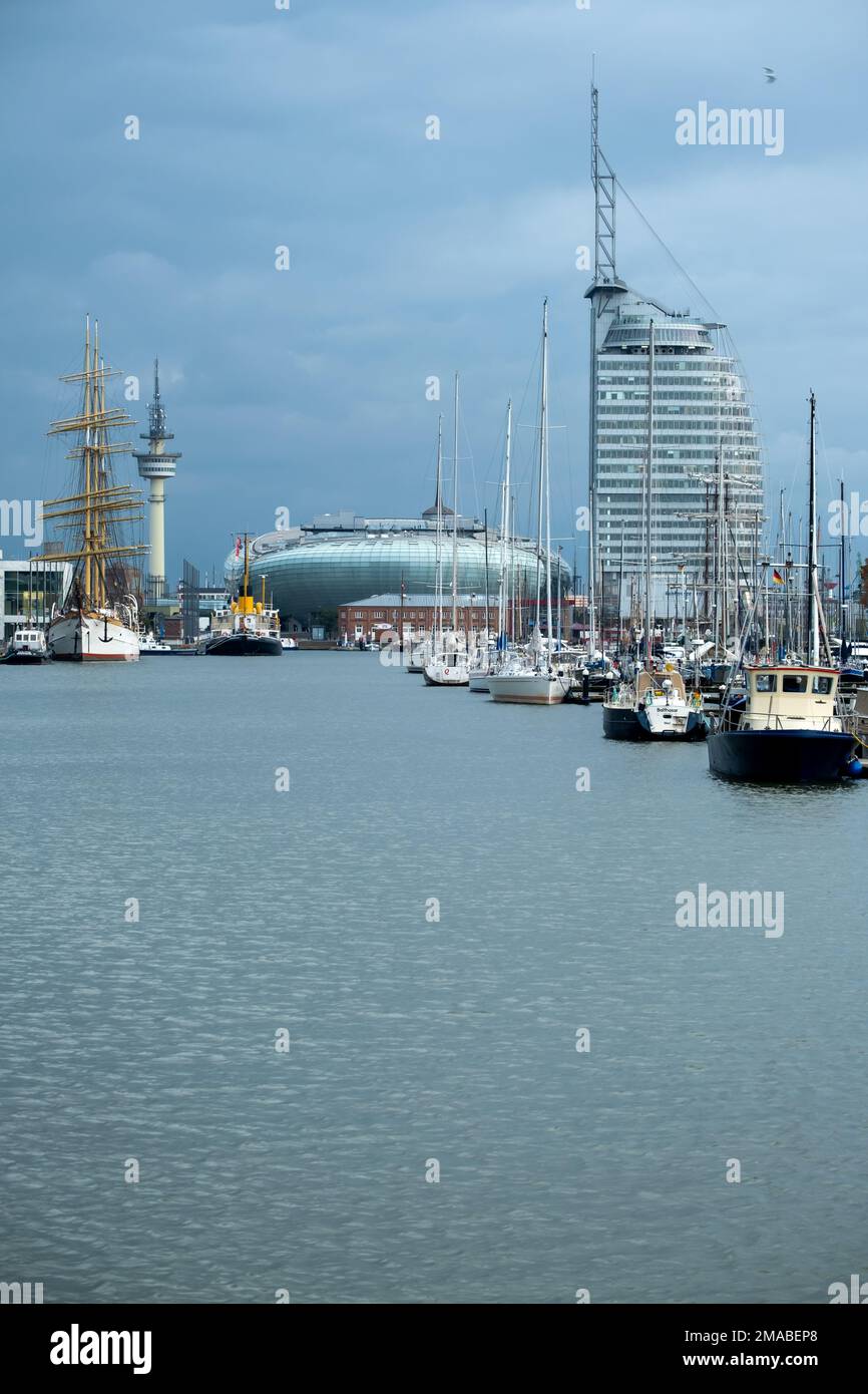 04.11.2021, Germania, Brema, Bremerhaven - Vista sul nuovo porto con Klimahaus Bremerhaven, navi, radio torre e sulla destra ATLANTIC Hotel Sail Cit Foto Stock