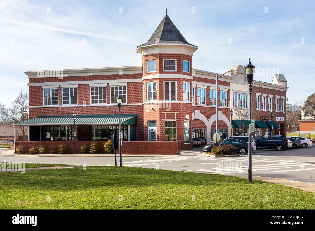 MATTHEWS, NC, USA-15 GENNAIO 2023: Elegante edificio commerciale multi-uso presso la Matthews Station di fronte al Municipio. Sole, cielo blu giorno. Foto Stock