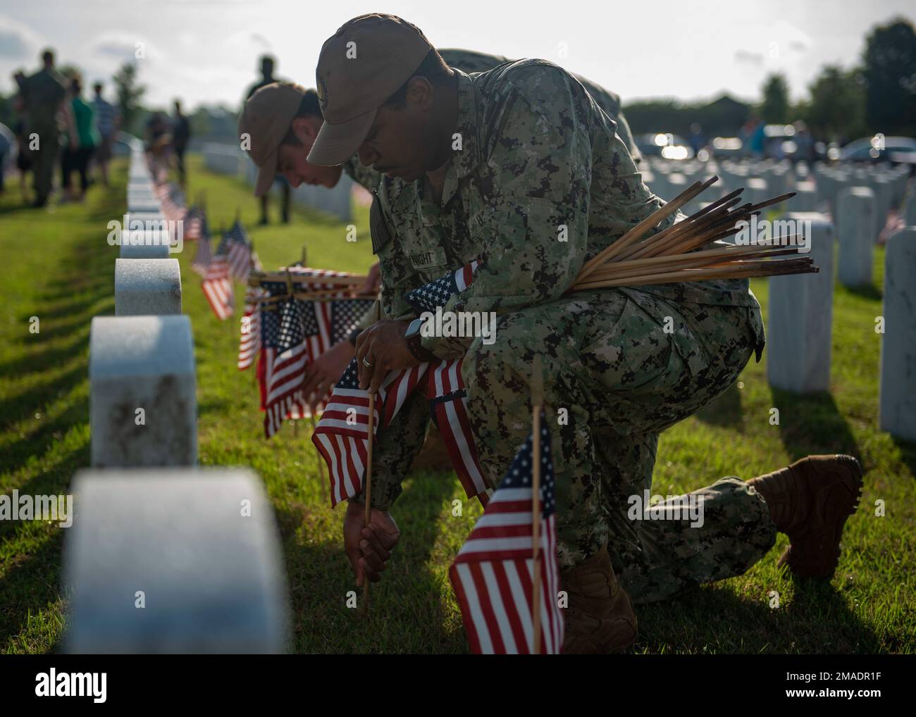 220526-N-KG461-1019 Jacksonville, Florida (26 maggio 2022) Specialista del programma religioso 3rd Classe Justin Knight mette una bandiera su una tomba al Jacksonville National Cemetery in preparazione al Memorial Day. Il personale militare e i civili si sono riuniti per mettere circa 22.000 bandiere in preparazione di una cerimonia di osservanza del Memorial Day. Il cimitero nazionale di 52 acri ospita oltre 16.000 monumenti commemorativi. Foto Stock