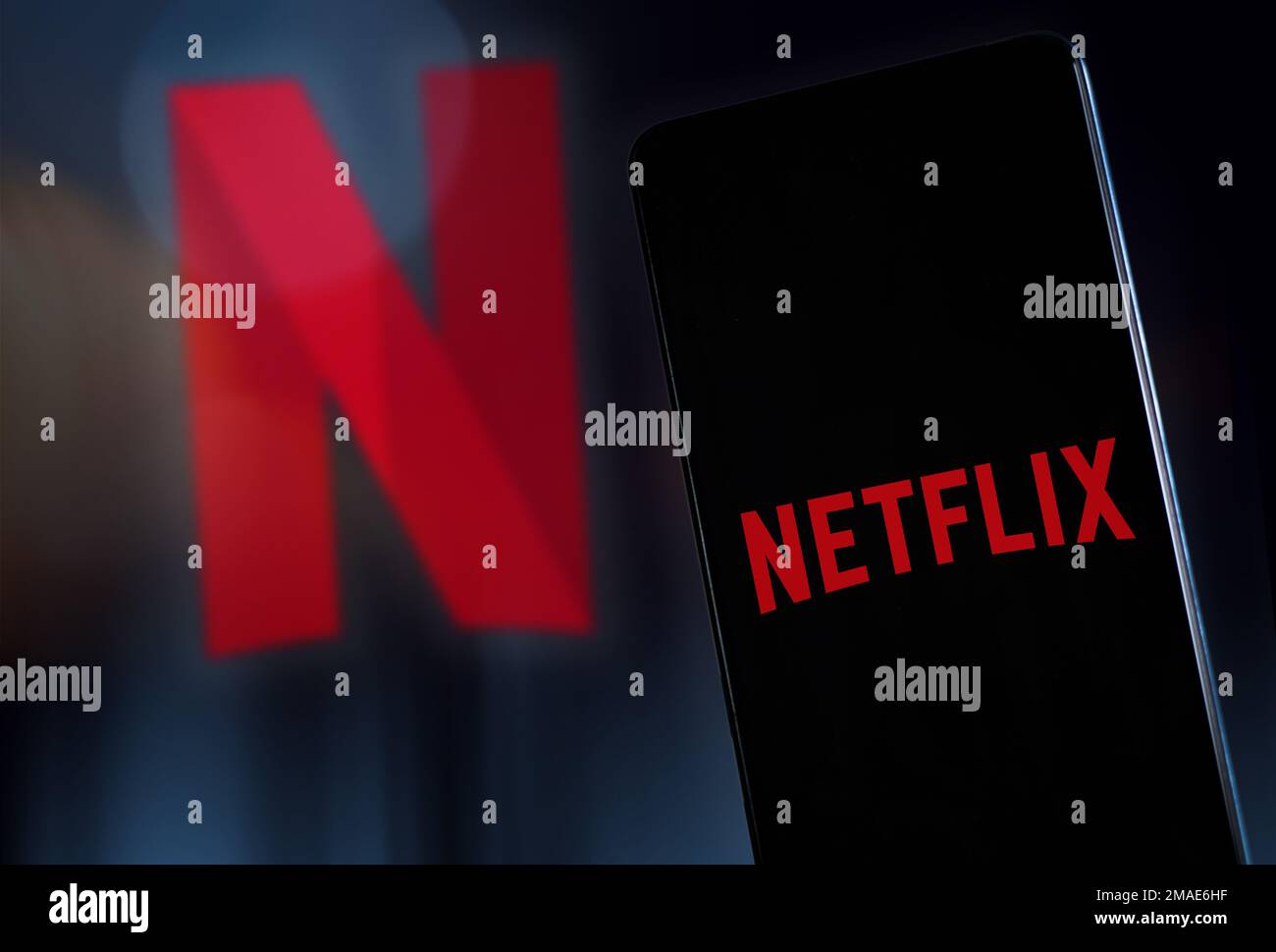 Logo Netflix sul display e sullo sfondo dello smartphone. Concetto di video di Straming. Milano Italia Gennaio 2023 Foto Stock