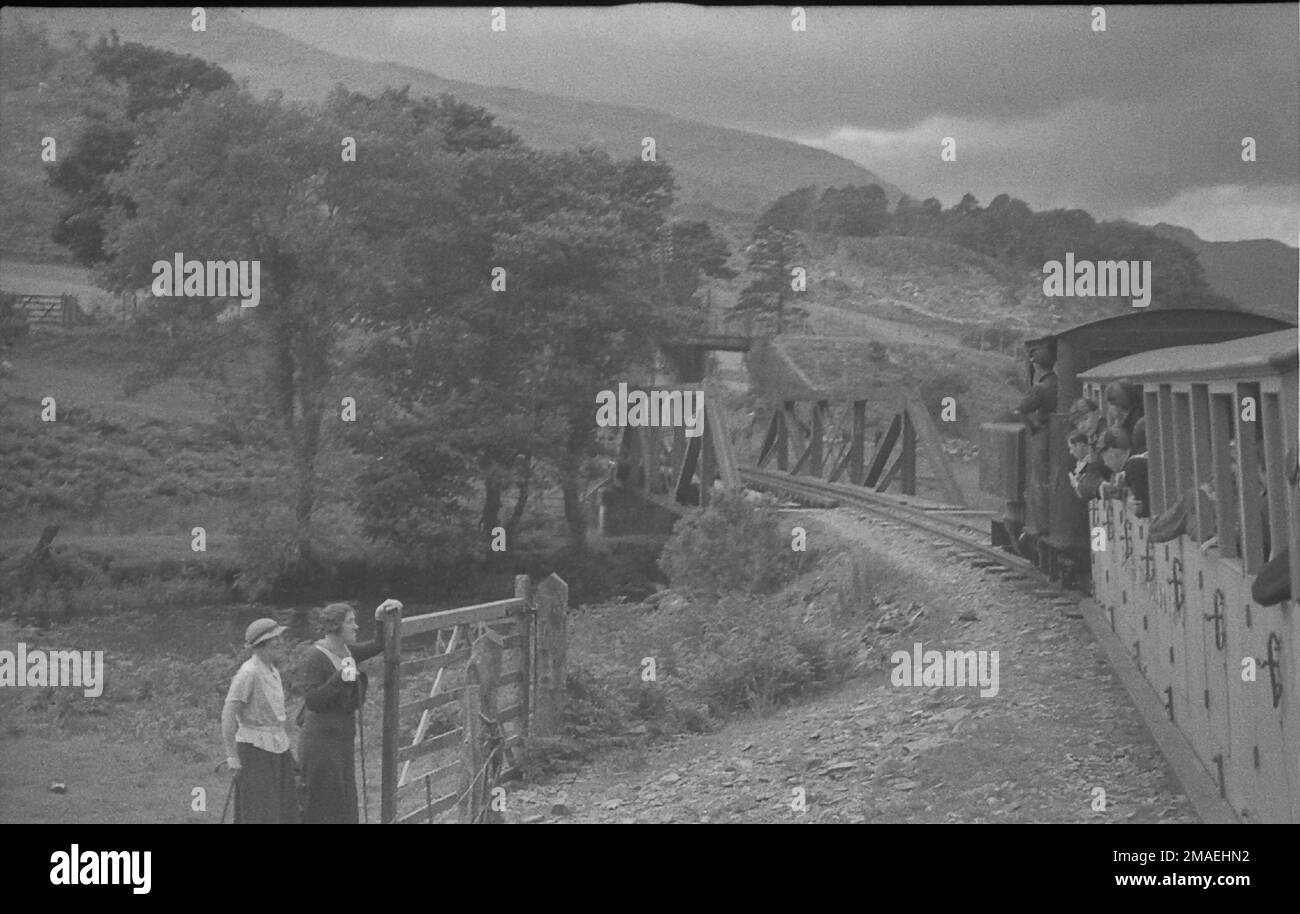 Ponte Bryn-y-Felin sulla West Highland Railway negli anni '1930s con due escursionisti che guardano un treno che attraversa Foto Stock