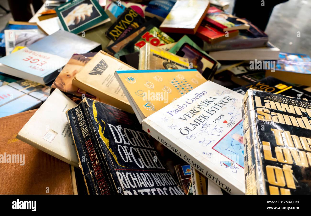 Libri cartacei assortiti, libri caoticamente gettati in un mucchio venduto nel mercato di Istanbul, Turchia Foto Stock