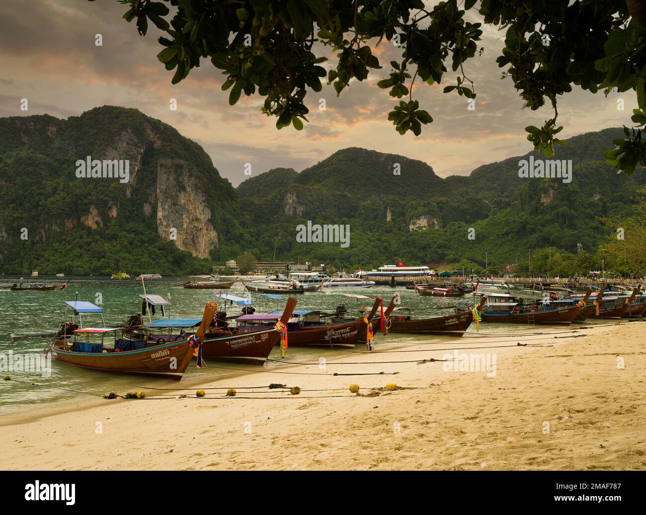 Phi Phi Island, Krabi, Thailandia. Dicembre 6, 2022. La famosa spiaggia di Ton Sai al tramonto. Barche tradizionali sulla spiaggia e splendida vista sulla baia Foto Stock