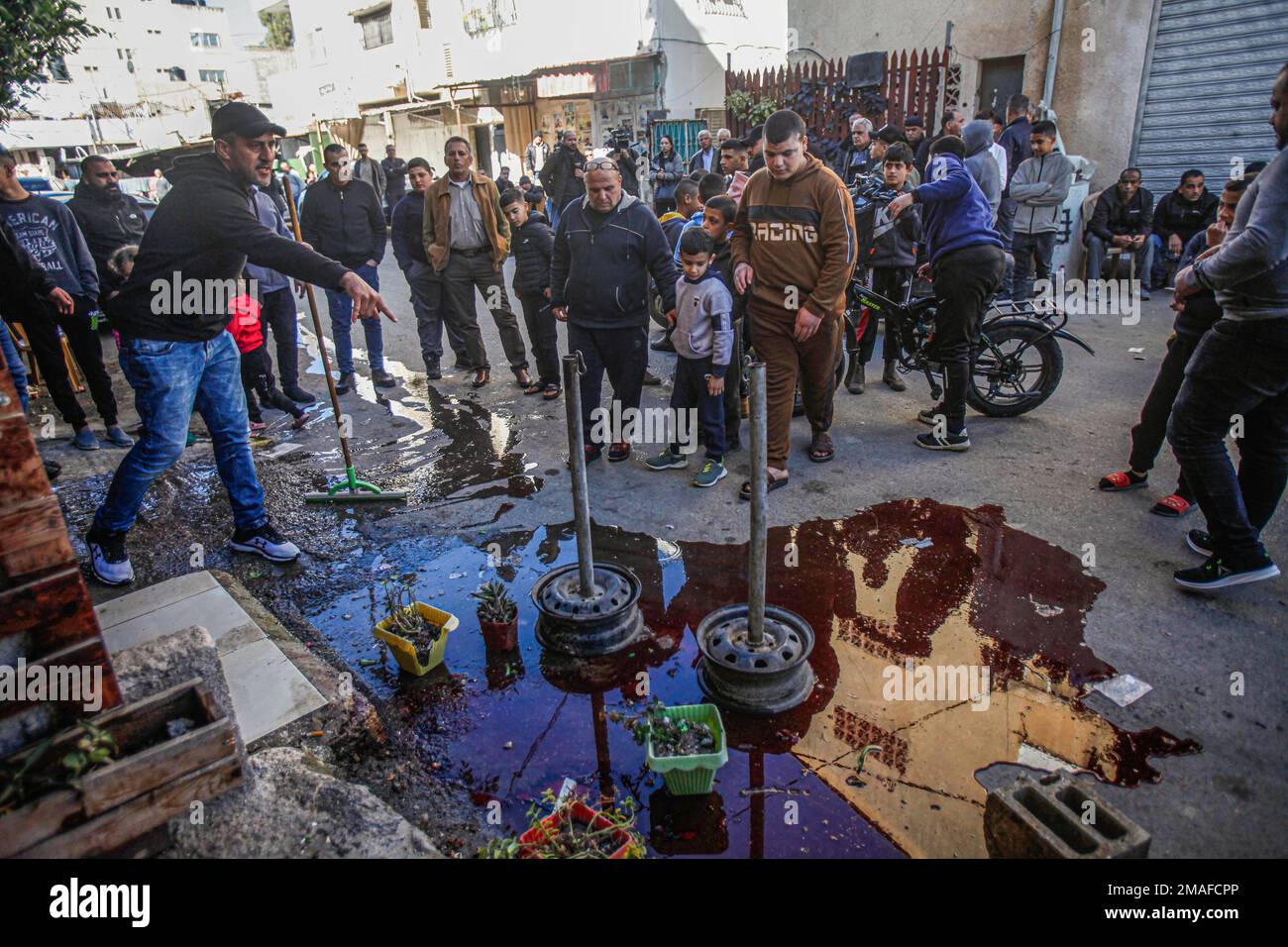 Jenin, Medio Oriente. 19th Jan, 2023. (NOTA PER I REDATTORI: L'immagine contiene contenuti grafici)i palestinesi ispezionano il luogo in cui i due palestinesi sono stati uccisi, Adham Jabareen, 28 anni, e l'insegnante di scuola Farid Bawaqna, 57 anni, che sono stati uccisi dalle pallottole dell'esercito israeliano durante un'incursione sul campo profughi di Jenin nella Cisgiordania occupata. Testimoni oculari hanno detto che Jabareen è stato ucciso a colpi di arma da fuoco dall'esercito israeliano, e l'insegnante di scuola Bawaqnah ha cercato di fornirgli il primo soccorso dopo che è caduto a terra. Durante il suo tentativo di aiutarlo, un cecchino israeliano lo sparò, e dopo di che il Foto Stock