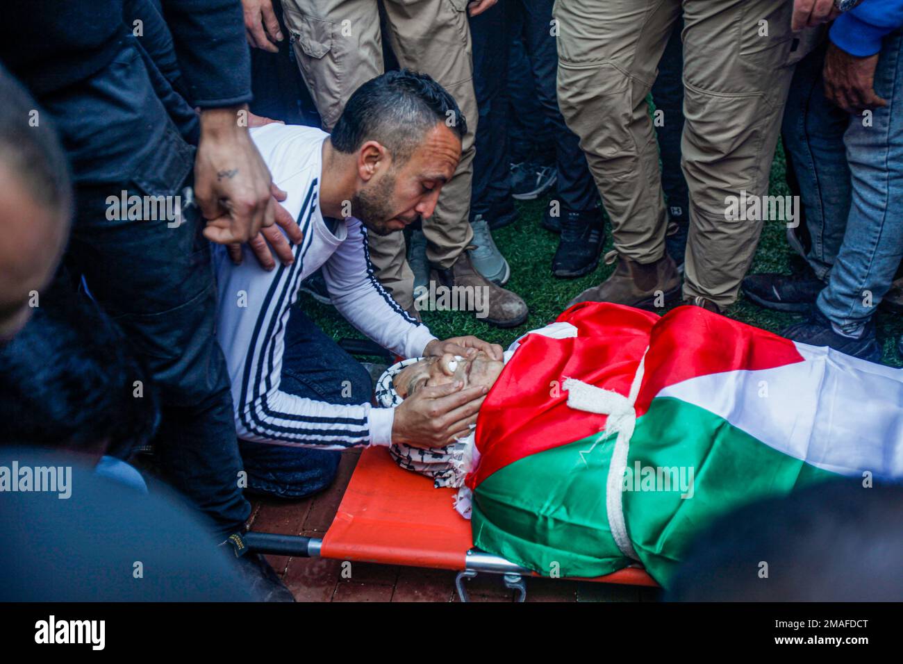 Jenin, Medio Oriente. 19th Jan, 2023. (NOTA DELL'EDITORE: Immagine raffigura la morte) i parenti si salutano e piangono accanto ai corpi dei due palestinesi, Adham Jabareen, 28 anni, e Jawad Bawaqneh, 57 anni, Che sono stati uccisi dalle pallottole dell'esercito israeliano durante un raid nel campo profughi di Jenin nella Cisgiordania occupata. Testimoni oculari hanno detto che Jabareen è stato ucciso a colpi di arma da fuoco dall'esercito israeliano, e l'insegnante di scuola Bawaqnah ha cercato di fornirgli il primo soccorso dopo che è caduto a terra. Durante il suo tentativo di aiutarlo, un cecchino israeliano lo sparò, e dopo di che le forze israeliane prepresero Foto Stock