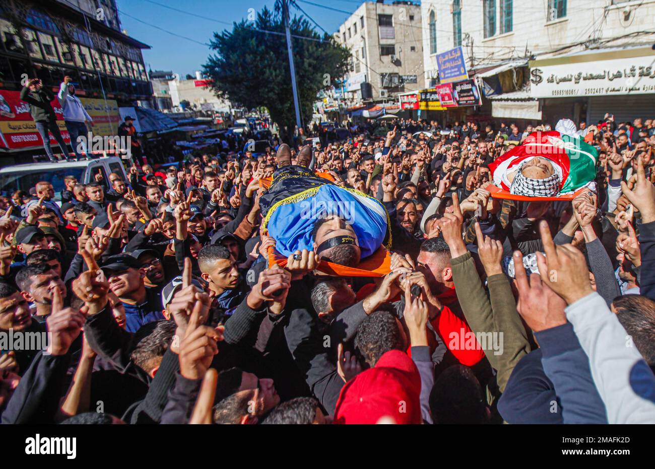 (NOTA DEL REDATTORE: Immagine raffigura la morte)i lutti e gli uomini armati portano i corpi dei palestinesi, Adham Jabareen, 28 anni, a sinistra, e l'insegnante di scuola Jawad Bawaqna, 57 anni, a destra, Che sono stati uccisi dai proiettili dell'esercito israeliano durante un raid nel campo profughi di Jenin, durante la cerimonia funeraria nella città di Jenin, nella Cisgiordania occupata. Testimoni oculari hanno detto che Jabareen è stato ucciso a colpi di arma da fuoco dall'esercito israeliano, e l'insegnante di scuola Bawaqnah ha cercato di fornirgli il primo soccorso dopo che è caduto a terra. Durante il suo tentativo di aiutarlo, un cecchino israeliano lo sparò, e dopo di lui Foto Stock