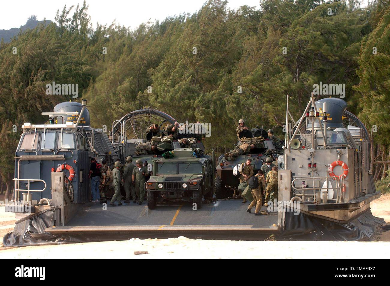 060722-N-9288T-131. [Completa] Didascalia scena: Un'imbarcazione US Navy (USN) Landing Craft Air-Cushion (LCAC) sbarcerà i Marine Corps (USMC) Marines dal 4th Light Armored Reconnaissance (LAR), Charlie Company (C CO) in una spiaggia presso la Bellows Air Force Station (AFS), Hawaii (HI), durante un addestramento di assalto anfibio durante l'esercitazione Rim of the Pacific (RIMPAC) 2006. Nella foto sono inoltre presenti i veicoli multiuso ad alta mobilità USMC (HMMWV) e un veicolo d'assalto anfibio (AAV) scaricati dalla LCAC. L'esercizio ha lo scopo di aumentare la competenza tattica delle unità partecipanti in una vasta gamma di Foto Stock