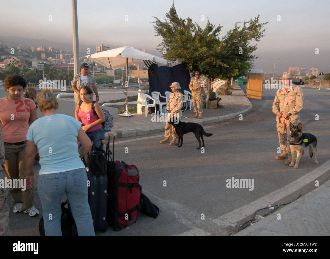 060725-N-6214F-004. [Completa] Didascalia scena: US Navy (USN) MASTER-at-Arms terza Classe (MA3) Gina Pronzati (a sinistra), con il suo cane da lavoro militare (MWD) Lucky, e USN MASTER-at-Arms seconda Classe (MA2) Mark Case (a destra), e MWD Benny, si preparano a controllare una fila di bagagli appartenenti a cittadini statunitensi durante un processo di screening di sicurezza prima dell'evacuazione a Cipro. Su richiesta dell'Ambasciatore degli Stati Uniti in Libano e sotto la direzione del Segretario alla Difesa (SECDEF), il comando centrale degli Stati Uniti (CENTCOM USA) e gli elementi della Task Force 59 stanno aiutando l'evacuazione dei cittadini statunitensi dal LEB Foto Stock