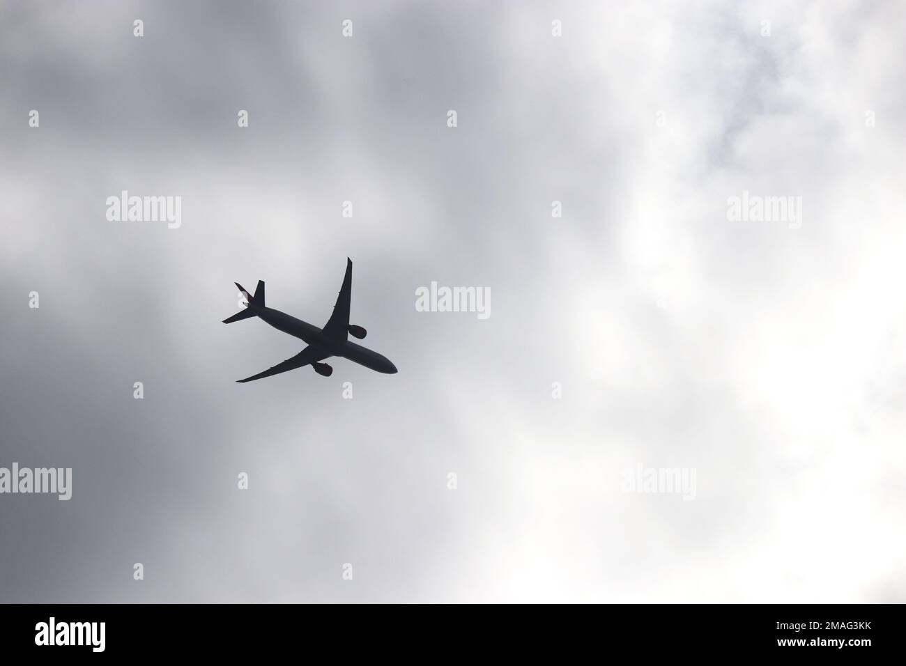 Silhouette di aeroplano su sfondo cielo tempesta. Aereo commerciale decollo tra nuvole scure, concetto di turbolenza Foto Stock