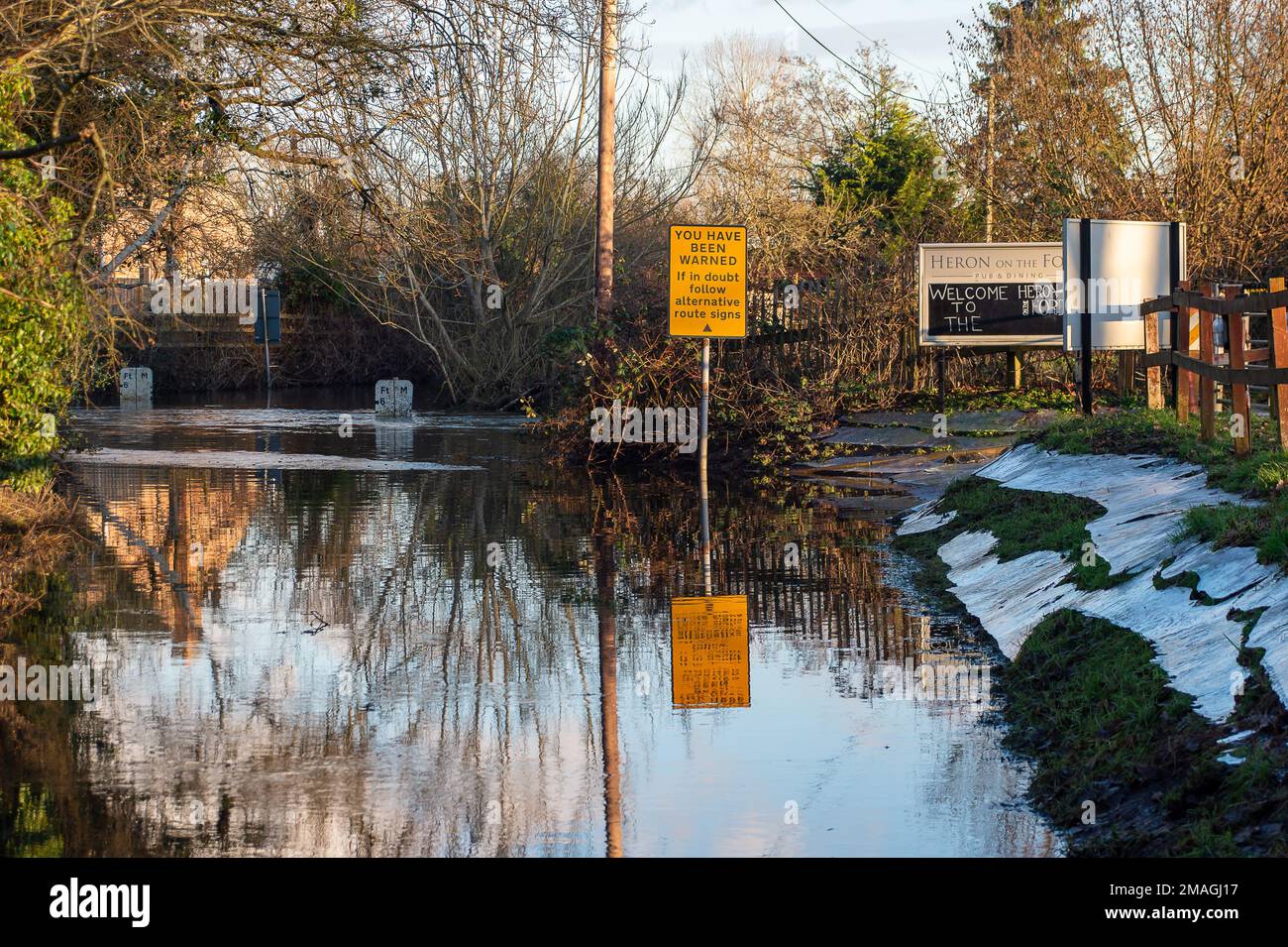 Charvil, Berkshire, Regno Unito. 19th gennaio 2023. Il Land's End Ford a Charvil, Berkshire, è attualmente chiuso al traffico, poiché i livelli dell'acqua hanno raggiunto appena meno di 6 metri di altezza. Il ford è noto per aver causato gli automobilisti di ottenere bloccati in acqua lì. Un allerta alluvione è in atto per il Lower River Loddon alla confluenza del Tamigi compreso Twyford, Charvil e Wargrave. Il pub accanto al Ford chiamato The Heron on the Ford è ancora aperto per affari, anche se il parcheggio sul retro non può essere raggiunto a causa dell'allagamento ford. Credit: Maureen McLean/Alamy Live News Foto Stock