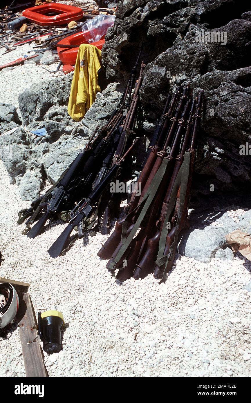 I fucili recuperati dal cacciatorpediniere filippino DATU KALANTIAW (ex-USS STAND DE-170) sono impilati a terra. La NAVE munizioni USS MOUNT HOOD (AE-29) sta assistendo nelle operazioni di salvataggio sul sito della nave captata. Base: Isola di Calayan Paese: Filippine Foto Stock