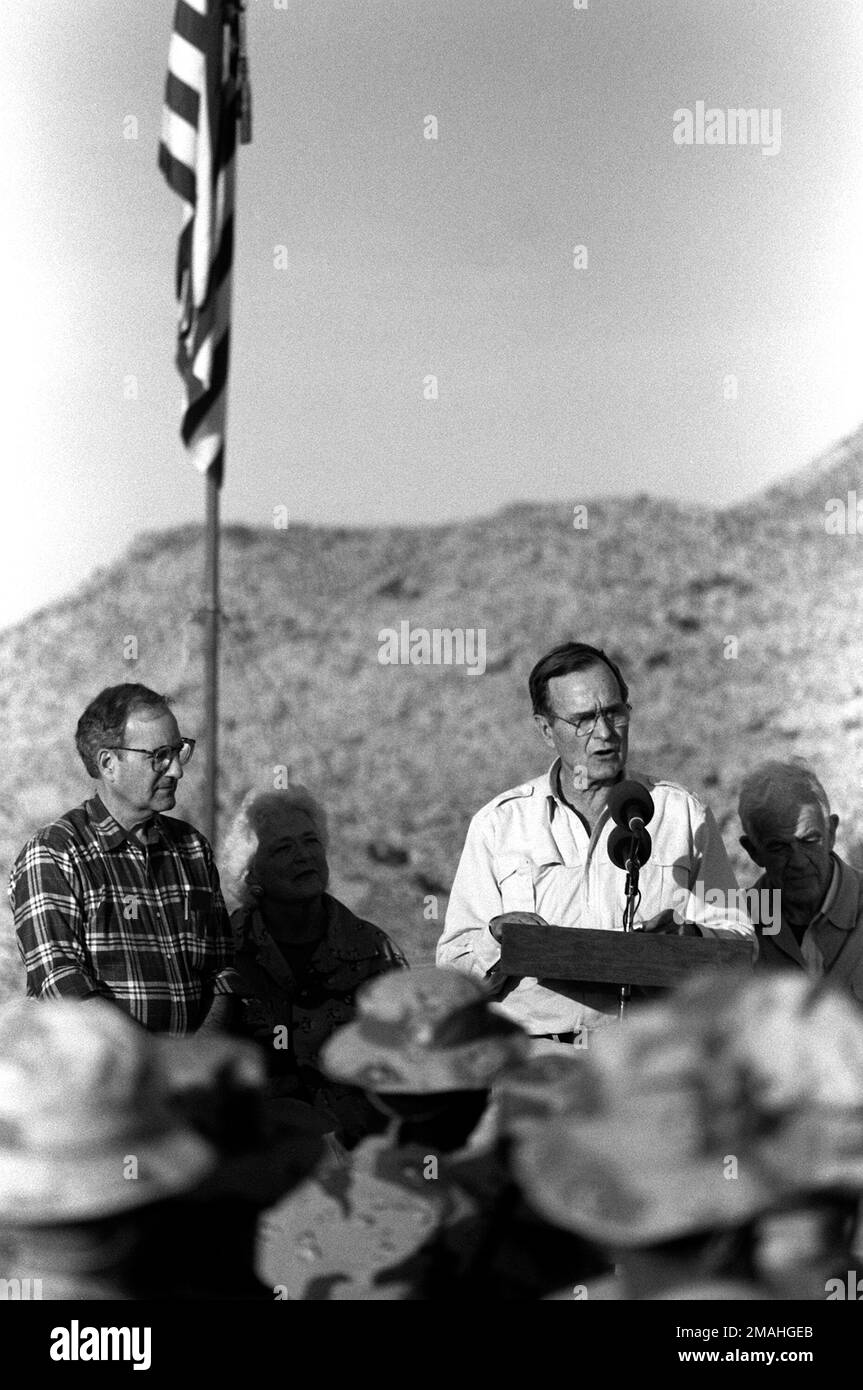 Il presidente George Bush parla ai Marines riuniti al 1st Marine Division Combat Operations Center (COC) il giorno del Ringraziamento durante l'operazione Desert Shield. Al presidente sono presenti il leader della minoranza della Camera Robert H. Michel di sinistra, la prima signora Barbara Bush, e il Presidente della Camera Tom Foley di destra. Subject Operation/Series: SCUDO DEL DESERTO Paese: Arabia Saudita (SAU) Foto Stock