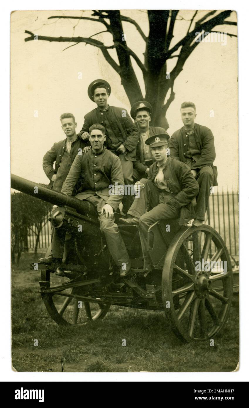 Cartolina originale del WW1 di un gruppo di giovani uomini del reggimento reale di Norfolk che si scompigliano in cima ad un campo di allenamento con una pistola da campo. Una rara fotografia di giovani che stanno per essere inviati in prima linea, eccitati a lasciare casa, prima che conoscano gli orrori delle trincee. Foraggio di cannone. Circa 1916 Regno Unito Foto Stock
