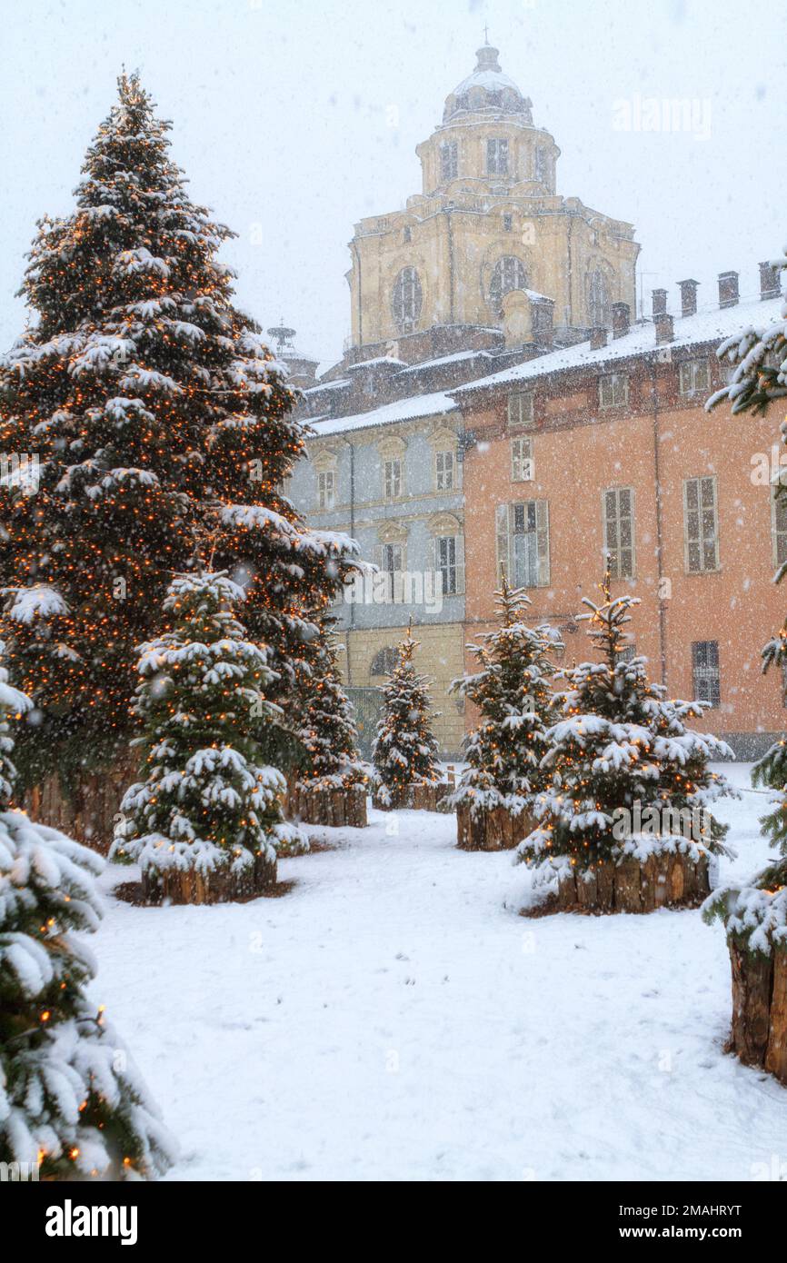 Alberi di Natale con neve davanti alla cupola della chiesa di San Lorenzo nel centro di Torino. Piazza Castello, Torino, Italia. Foto Stock