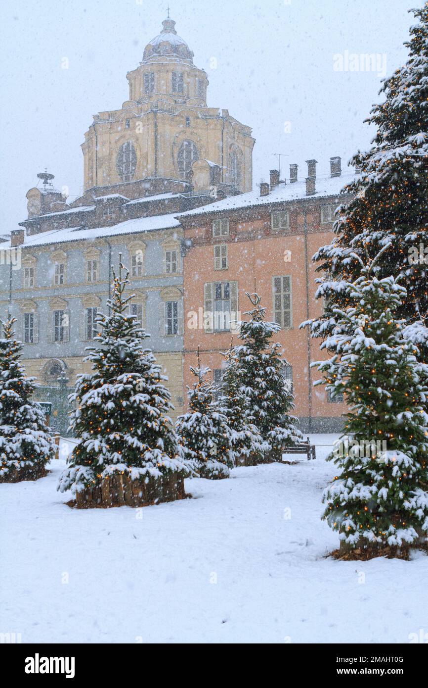 Alberi di Natale con neve davanti alla cupola della chiesa di San Lorenzo nel centro di Torino. Piazza Castello, Torino, Italia. Foto Stock