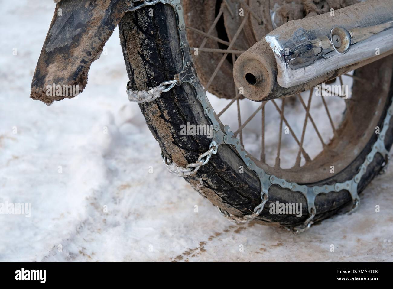 Primo piano di una moto con catene da neve Foto stock - Alamy