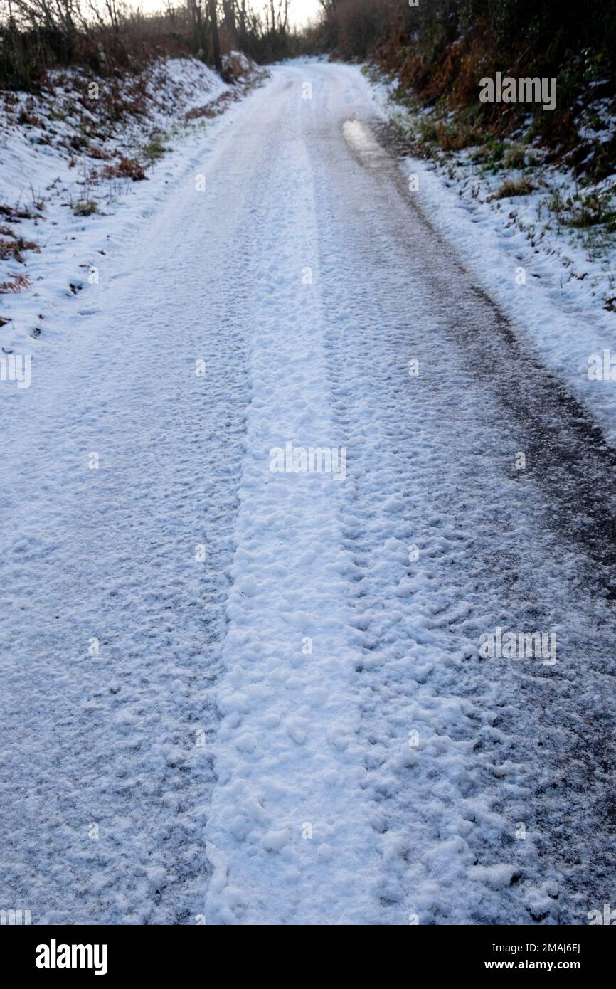 Ghiaccio e neve ghiacciata sulla strada rurale corsia di campagna in inverno gennaio 2023 Carmarthenshire Galles Regno Unito Gran Bretagna KATHY DEWITT Foto Stock