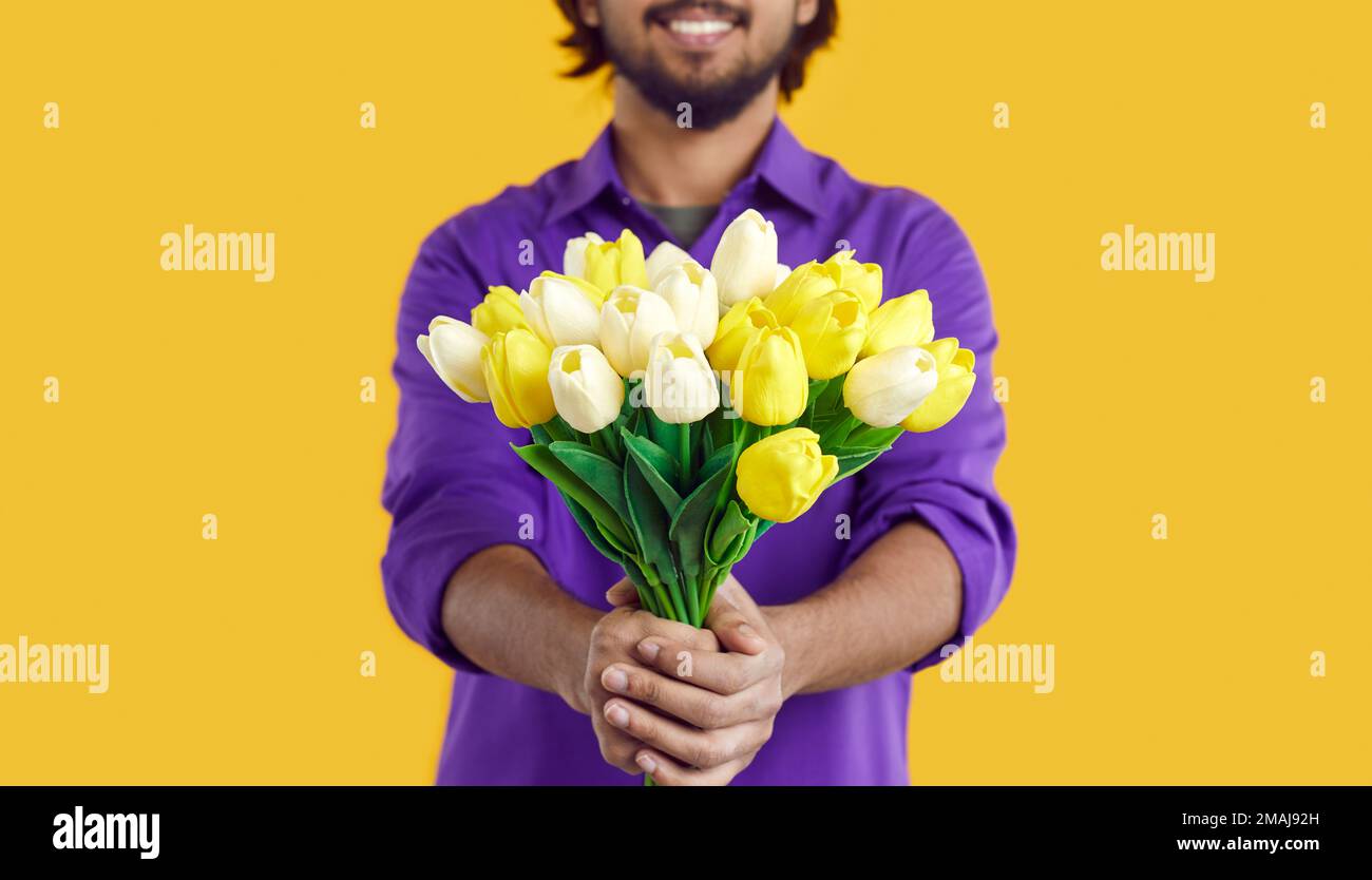 Mani uomo stretching in avanti bouquet di fiori di tulipano giallo per fidanzata durante la data romantica Foto Stock