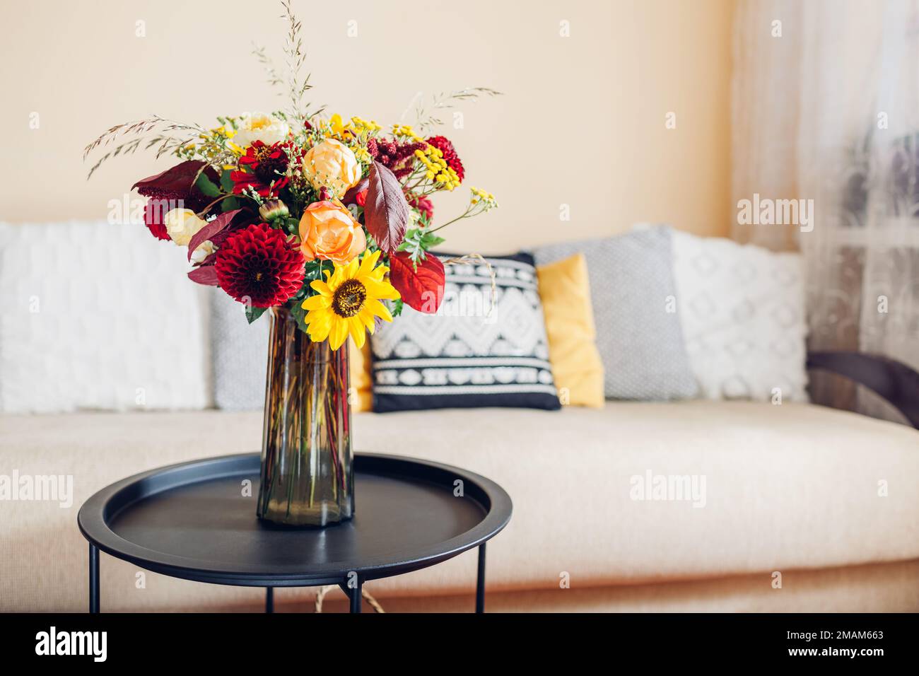 Disposizione dei fiori sul tavolo. Primo piano del bouquet autunnale di rose dahlias girasoli e zinnie in vaso a casa. Foto Stock