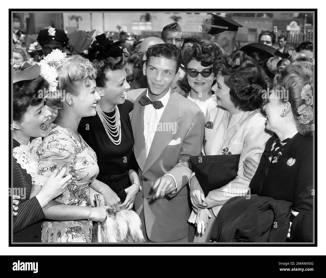 FRANK SINATRA 1940s Frank Sinatra indossa una cravatta da fiocco, in piedi con un gruppo di tifosi adoranti a Pasadena, California, il 11 agosto 1943, pochi giorni prima della sua esibizione presso l'Hollywood Bowl. Hollywood, Stati Uniti Foto Stock