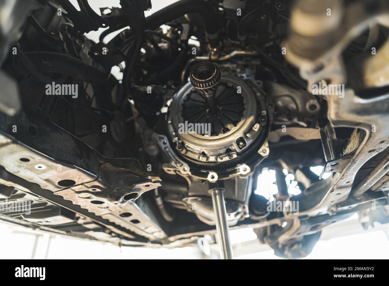 Rimozione e installazione di un nuovo kit frizione per una vettura in un'officina di riparazione auto. Foto di alta qualità Foto Stock