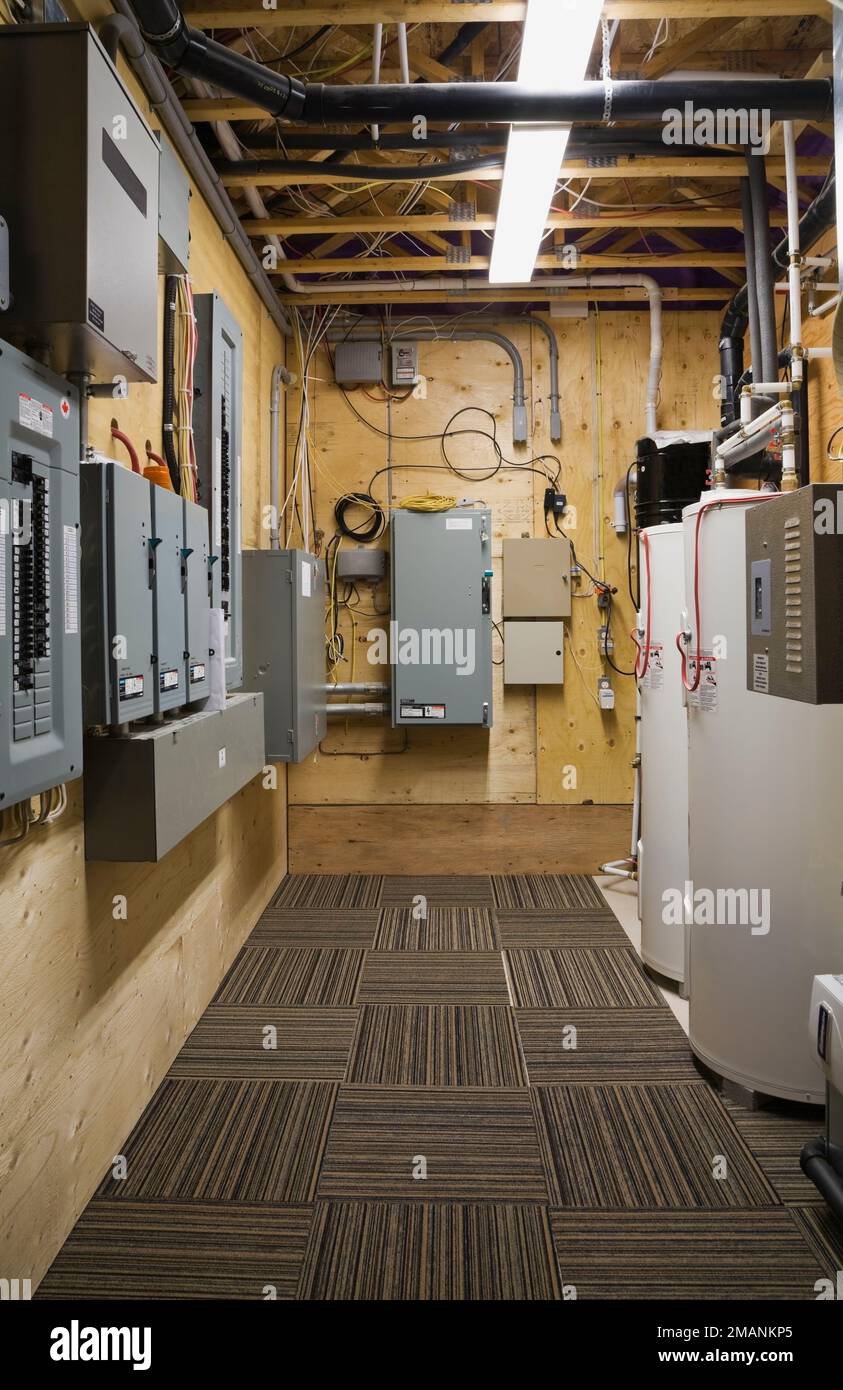 Pannelli elettrici e serbatoi di acqua calda in ripostiglio nel seminterrato all'interno di lussuoso scandinavo tronchi e legno telaio casa. Foto Stock