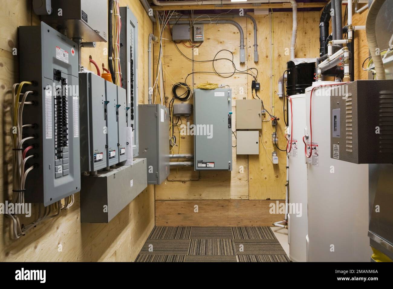 Pannelli elettrici e serbatoi di acqua calda in ripostiglio nel seminterrato all'interno di lussuoso scandinavo tronchi e legno telaio casa. Foto Stock