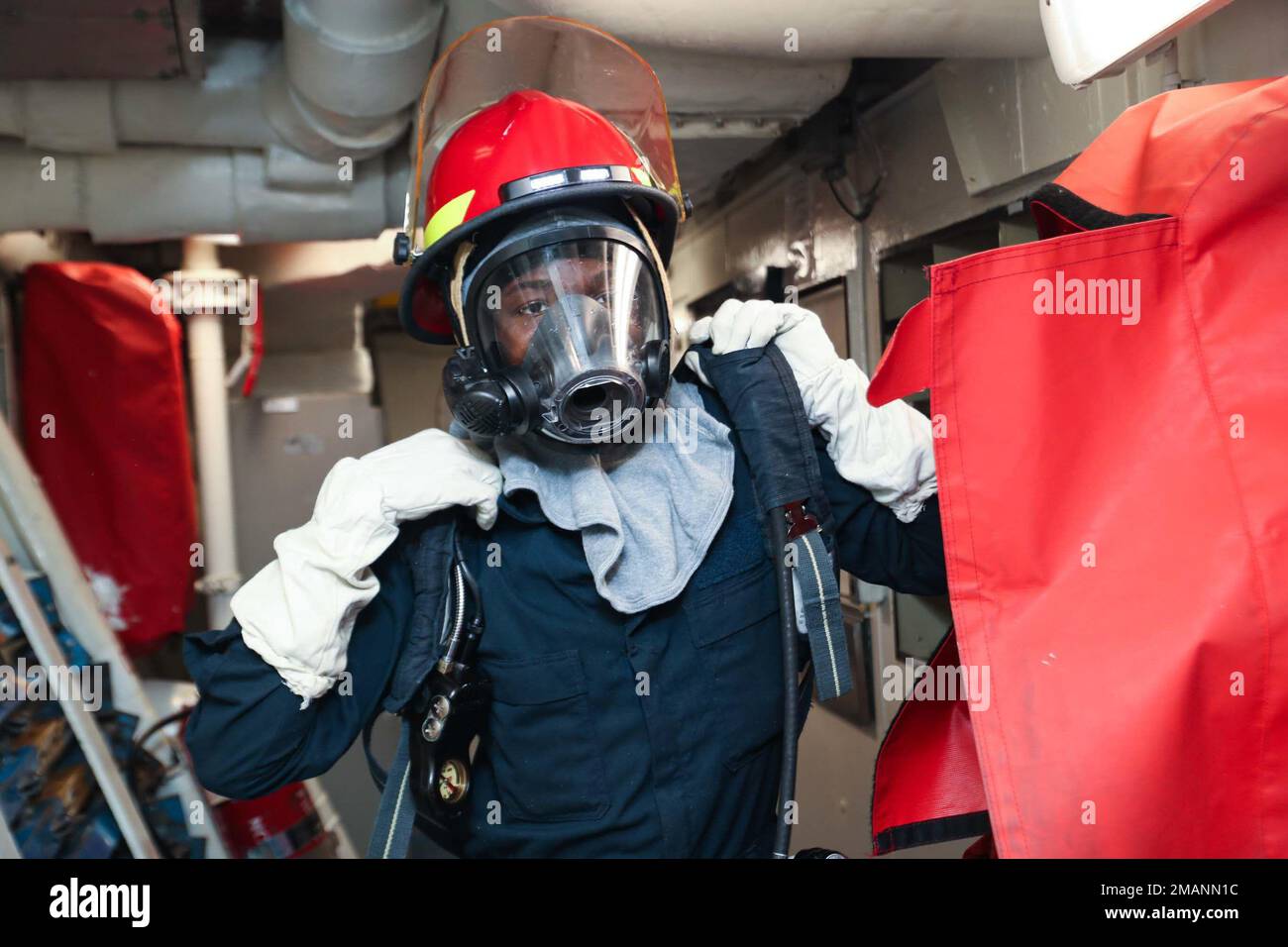 PHILIPPINE SEA (1 giugno 2022) gas turbine Systems Technician (Mechanical) Fireman Apprentice Jahmal Fragelus, di Indianapolis, è dotato di un autorespiratore autonomo (SCBA) durante un'esercitazione di controllo dei danni a bordo dell'incrociatore missilistico guidato di classe Ticonderoga USS Mobile Bay (CG 53). Abraham Lincoln Strike Group è in fase di implementazione pianificata nell'area delle operazioni della flotta 7th degli Stati Uniti per migliorare l'interoperabilità attraverso alleanze e partnership e al tempo stesso fungere da forza di risposta pronta a sostegno di una regione indomPacifico libera e aperta. Foto Stock