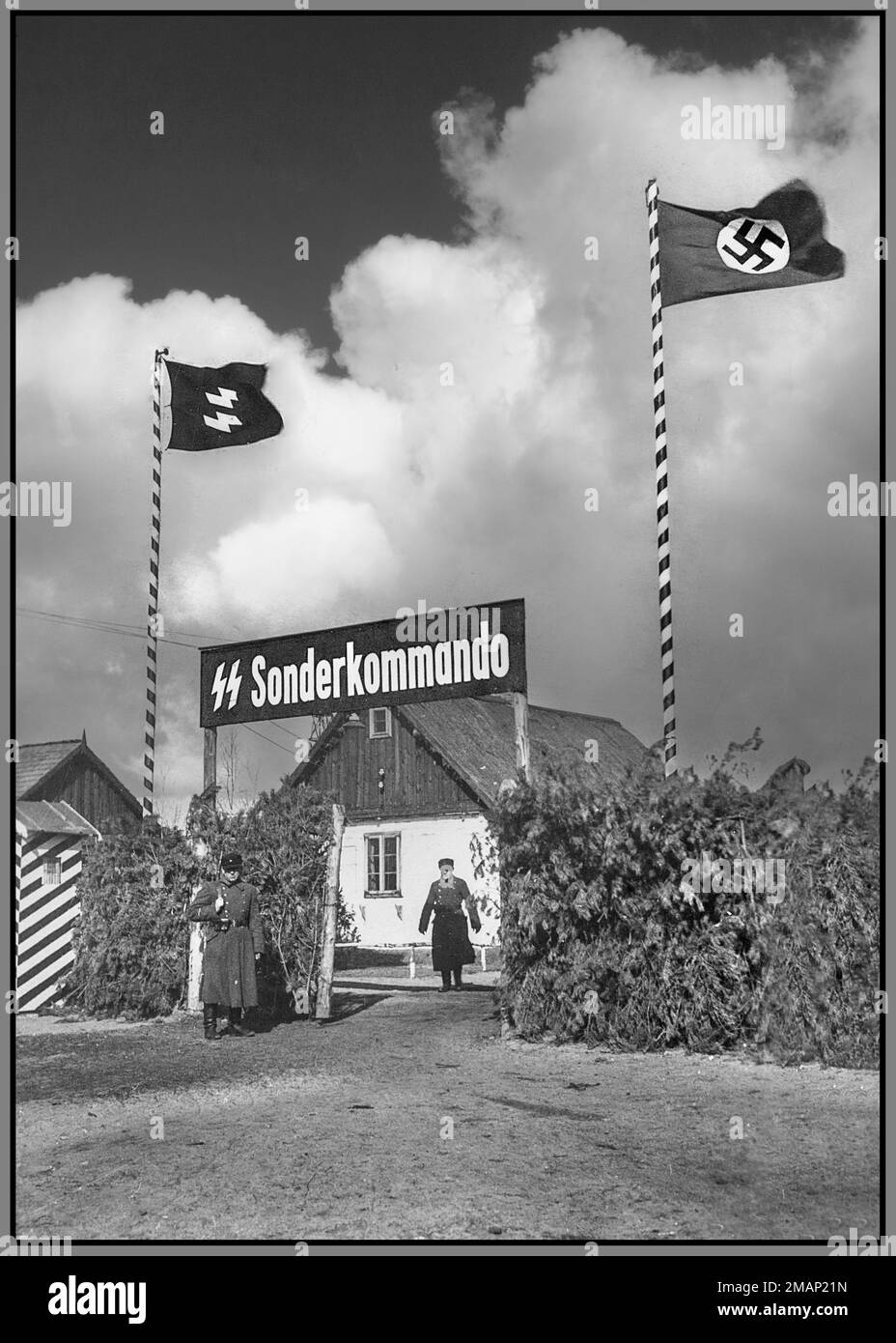 SOBIBOR STERMINIO INGRESSO CAMPO SONDERKOMMANDO 1942-43 cancello d'ingresso al campo di sterminio nazista Sobibor nella Polonia occupata dalla Germania nazista. Bandiere naziste Waffen SS e Swastika che volano sopra. Sonderkommandos erano unità di lavoro costituite da prigionieri del campo di sterminio nazista tedesco. Erano composti da prigionieri, di solito ebrei, che erano stati costretti, a rischio di morte, ad aiutare le vittime della camera a gas durante l'Olocausto. Il campo di sterminio Sonderkommandos, che erano sempre detenuti, non era collegato alle SS-Sonderkommandos, che erano unità ad hoc formate da membri di vari uffici SS Foto Stock