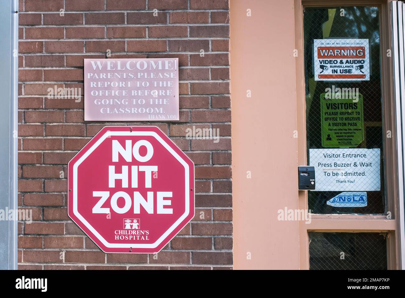 NEW ORLEANS, LA, USA - 9 DICEMBRE 2022: Segnali e buzzer relativi alla protezione dei bambini all'ingresso visitatori di St Giovanna d'Arco Scuola Foto Stock