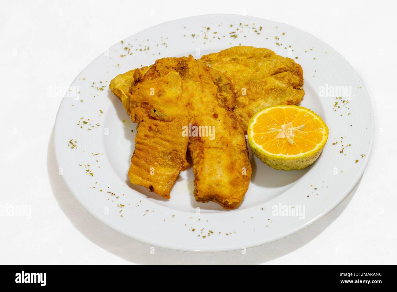 filetto di pesce fritto su un piatto su fondo bianco Foto Stock