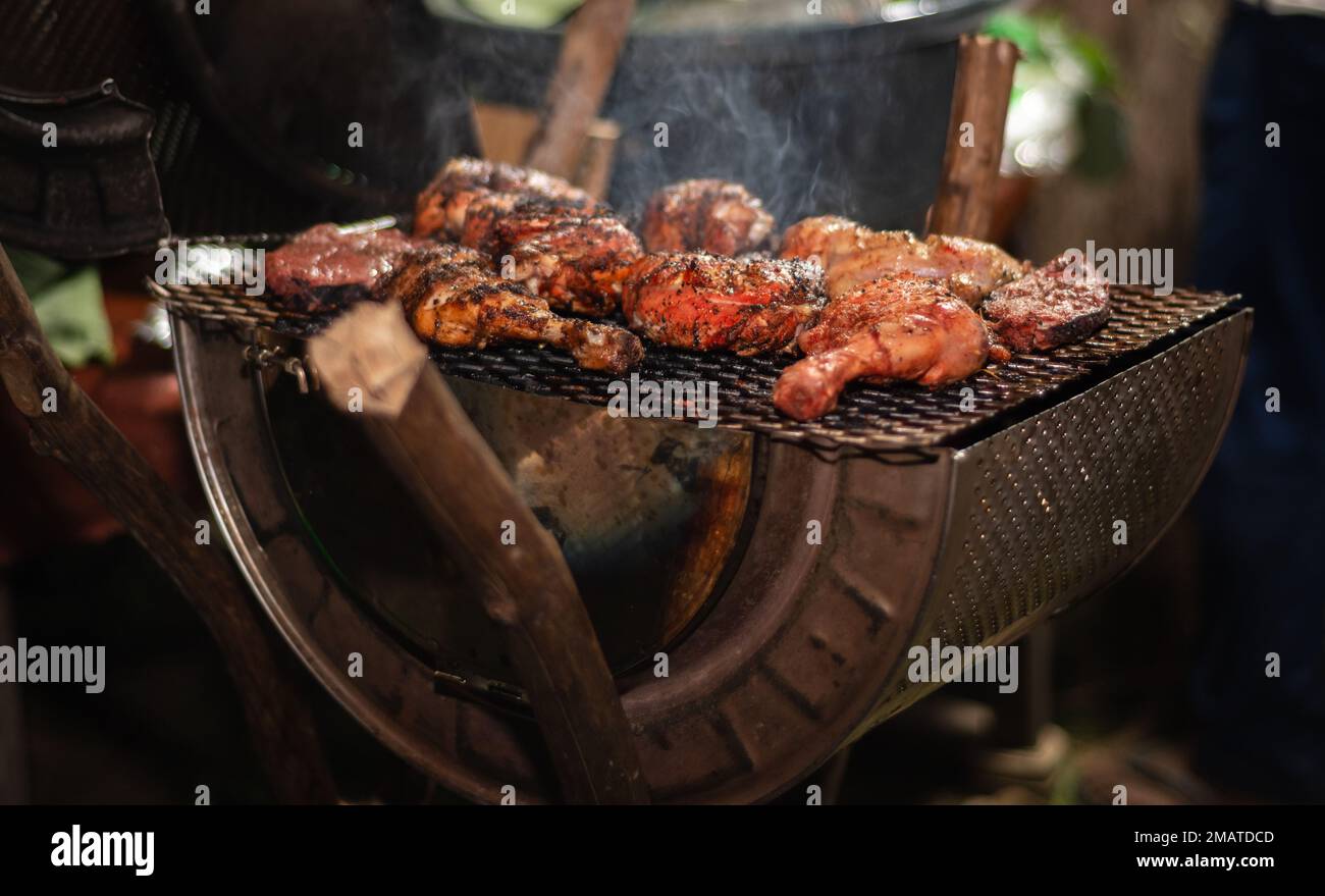 Barbequing di pollo drumsticks su un barbecue grill, Foto Stock
