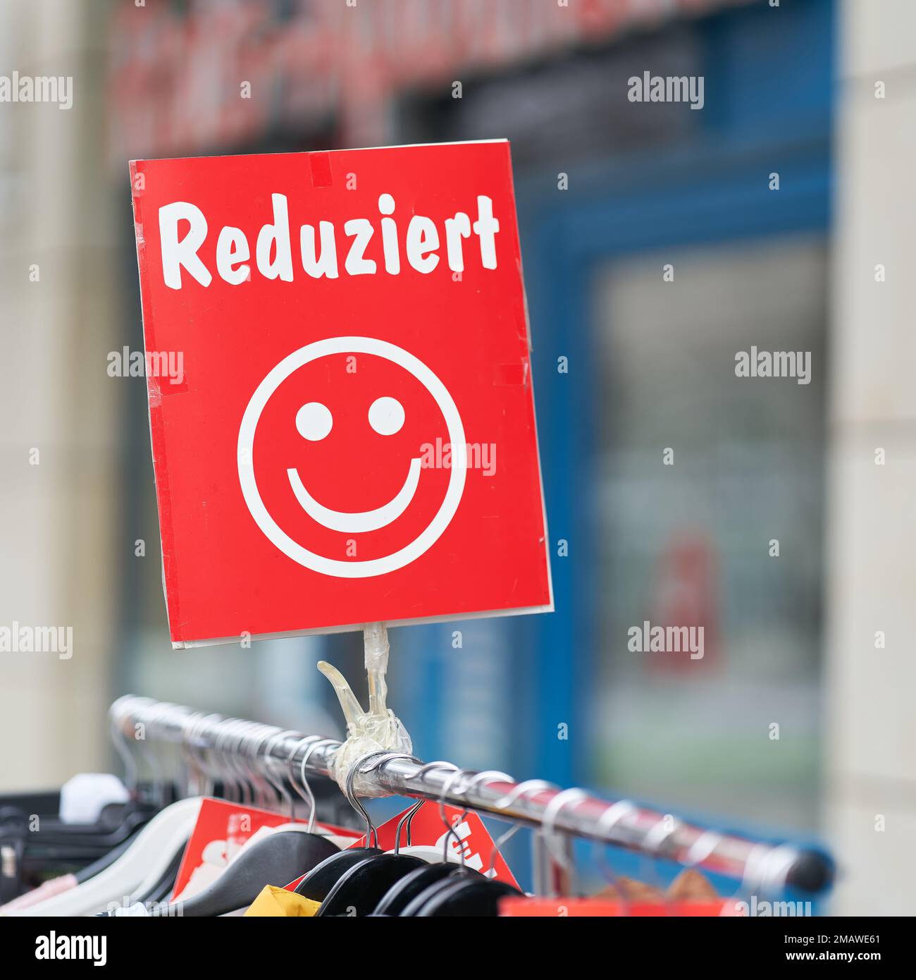 Cartello con iscrizione tedesca Reduziert, che indica l'abbigliamento in offerta speciale di fronte ad un negozio a Magdeburgo in Germania. Traduzione: Ridotta Foto Stock