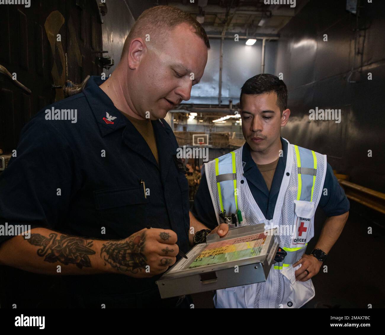 220606-N-CJ603-2149 OCEANO ATLANTICO - (6 giugno 2022) — Religious Programs Specialist 2nd Class Jesse Seward, a sinistra, assiste il Lt. Dean Luttrell, ufficiale di triage, documenta le lesioni dei pazienti durante un'esercitazione di incidenti di massa a bordo della nave portuale Harpers Ferry USS carter Hall (LSD 50), 6 giugno 2022. Carter Hall è attualmente in corso di esecuzione di operazioni di routine. Foto Stock