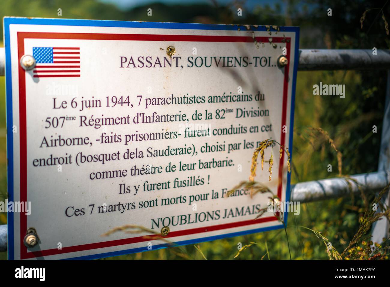 Passando, ricordate... Il 6 giugno 1944, 7 paracadutisti americani del 507th° reggimento della fanteria, 82nd° divisione aerea, prigionieri, sono stati portati in questo luogo (boschetto di Sauderaie), scelto dai nazisti come teatro della loro barbarie. Sono stati sparati lì! Questi 7 martiri sono morti per la Francia. Non dimenticare mai…. Foto Stock