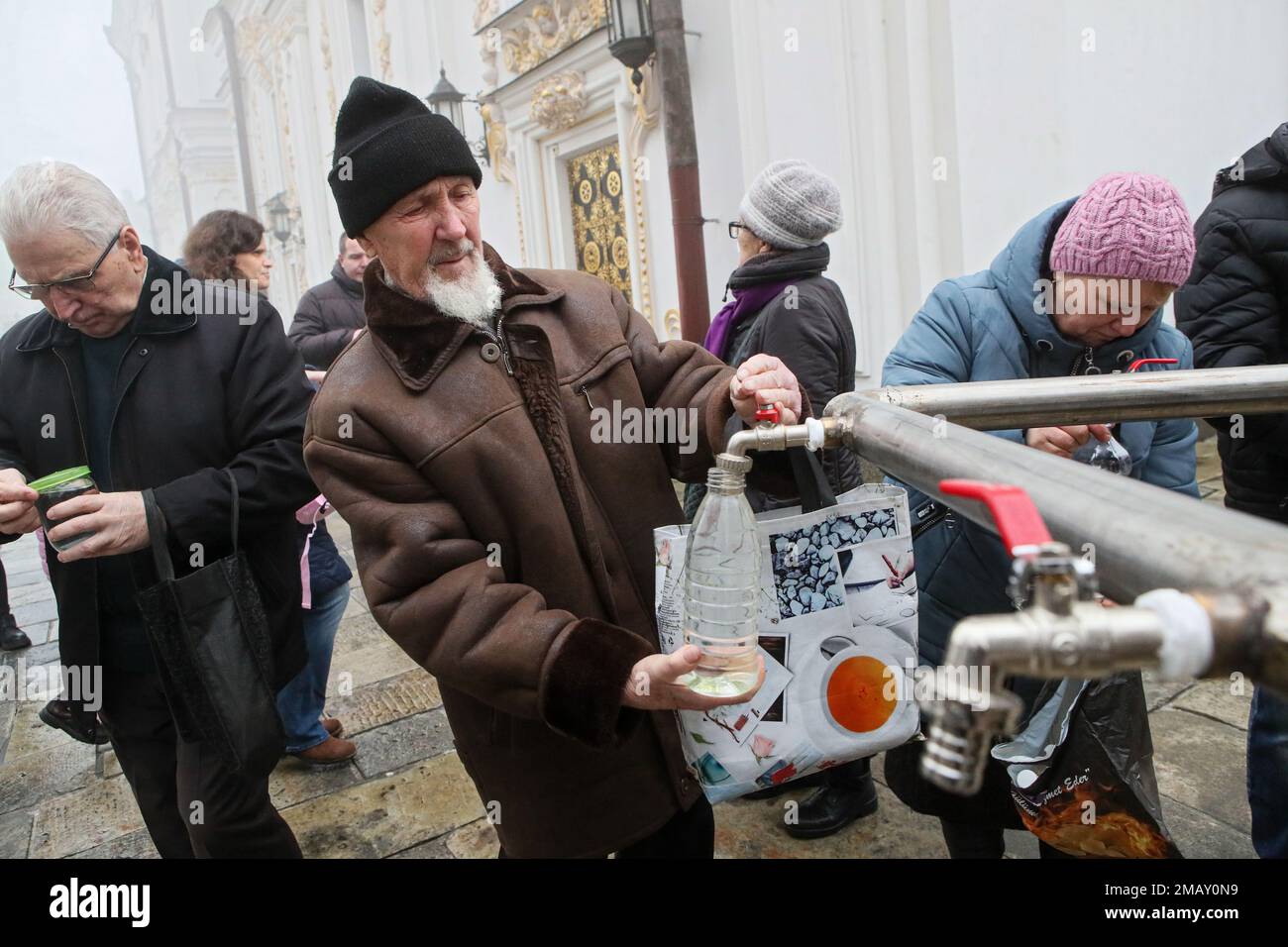 Non esclusiva: KYIV, UCRAINA - 19 GENNAIO 2023 - Un uomo riempie una bottiglia d'acqua alla Cattedrale di Dormition del Kyiv Pechersk Lavra su Epifania, Kyiv, Foto Stock