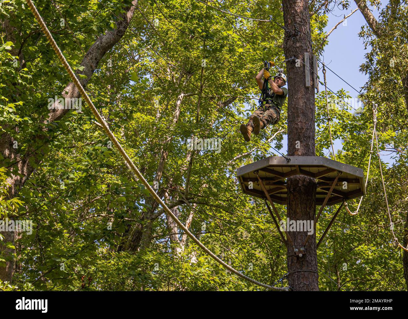 STATI UNITI Marine Corps Lance CPL. Tristen Reed, a Mayfield, Kentucky, videografo nativo e di combattimento assegnato a Headquarters e Headquarters Squadron, zipline sul corso sfida corde a Devil Dog dare, Marine Corps Air Station Cherry Point, North Carolina, 8 giugno 2022. Durante una visita di orientamento, gli specialisti dei programmi ricreativi della Marine Corps Community Services Headquarters hanno avuto la possibilità di vedere Devil's Dog dare e le sue attrazioni che sono offerti gratuitamente ai membri del servizio attivo. Foto Stock