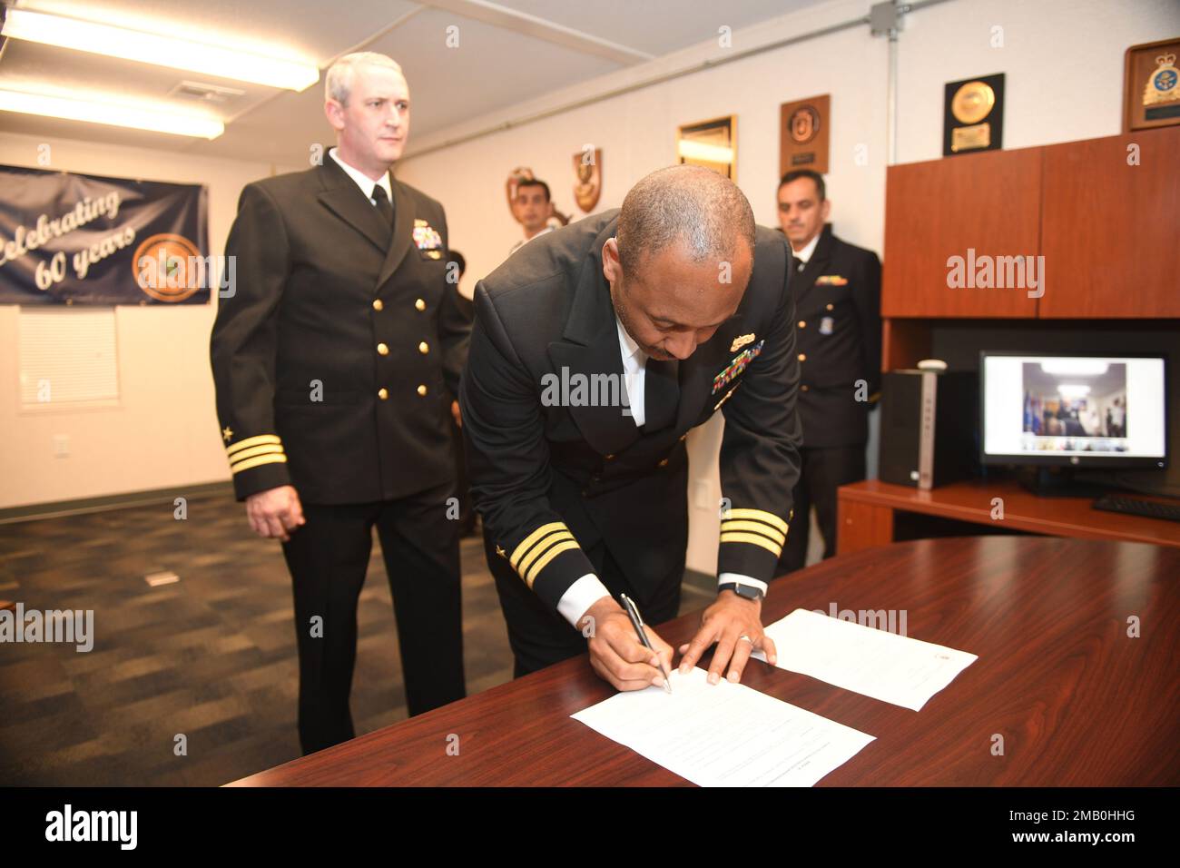 220607-N-DB801 -0105 MAYPORT, FLA. -- (9 giugno 2022) – CMdR. Lee Bush, off going Secretary of the Inter-American Naval Telecommunications Network (IANTN), firma gli ordini come egli è sollevato da CMdR. Craig McLemore durante una cerimonia di turnover negli Stati Uniti Naval Forces Southern Command/U.S. 4th Fleet Headquarters, 9 giugno 2022. Fondata nel 1962, la IANTN comprende ora 19 paesi che mantengono un collegamento di comunicazione permanente tra le autorità navali delle Americhe. STATI UNITI Naval Forces Southern Command/U.S. 4th Fleet ospita lo staff multinazionale IANTN, che sovrintende ai distaccamenti e ai centri operativi di IANTN Foto Stock