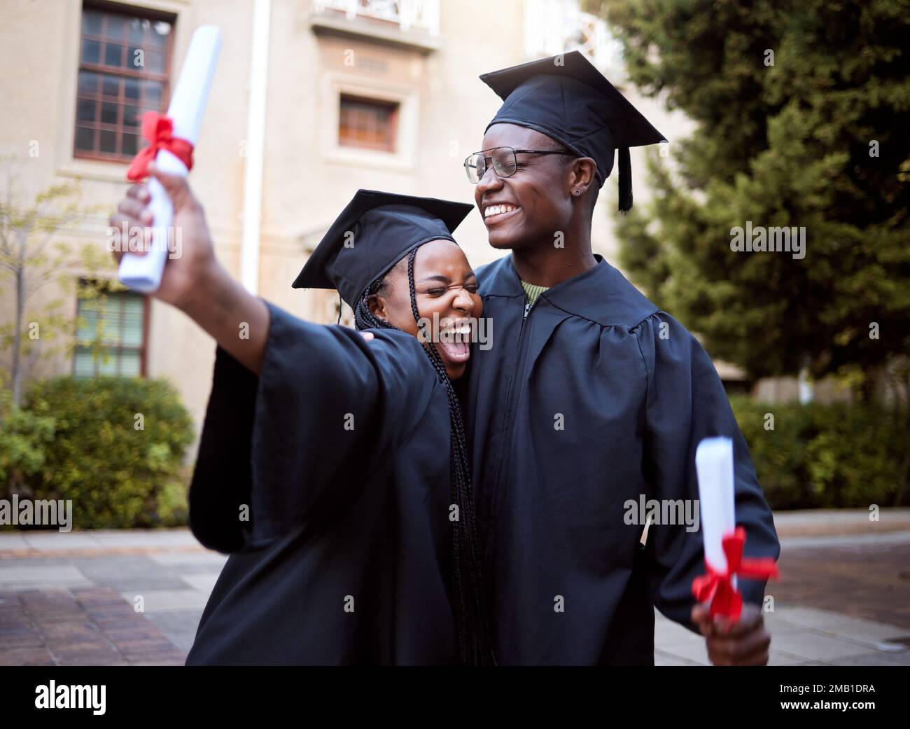 Studenti neri, abbraccio e celebrazione per la laurea, l'istruzione e il successo in università, campus e successo. Donna afroamericana, uomo o. Foto Stock